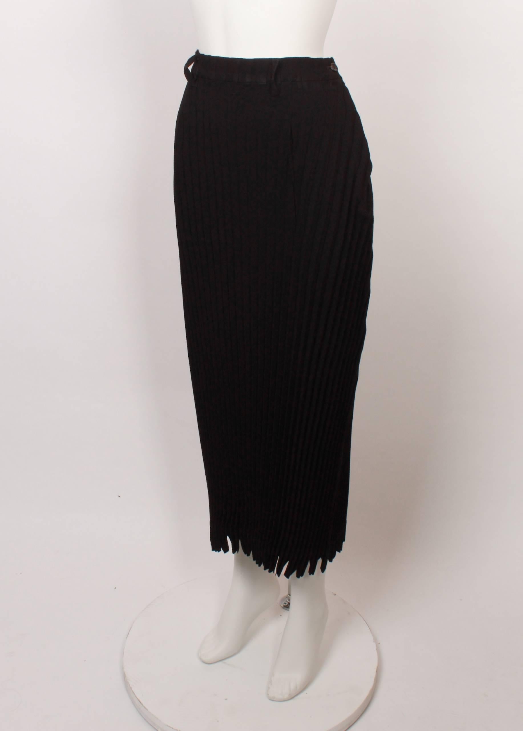 Classic yet always contemporary, 1990s Issey Miyake 3/4 length black skirt in iconic Issey Miyake textural pleats that hug the body. 
Features belt loops and button closure.
The pleats make the fabric slightly stretchy and hip measurements are with