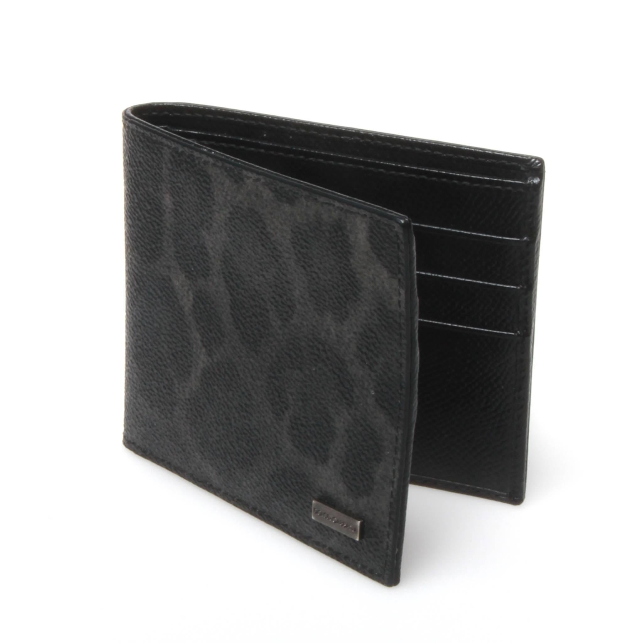 Dolce and Gabbana bi-fold dauphine calf leather wallet featuring a leopard print design in dark tones. Plain black interior features 6 card slots and sleeve for notes and receipts. Aged silver-tone metal brand plaque to front side. 