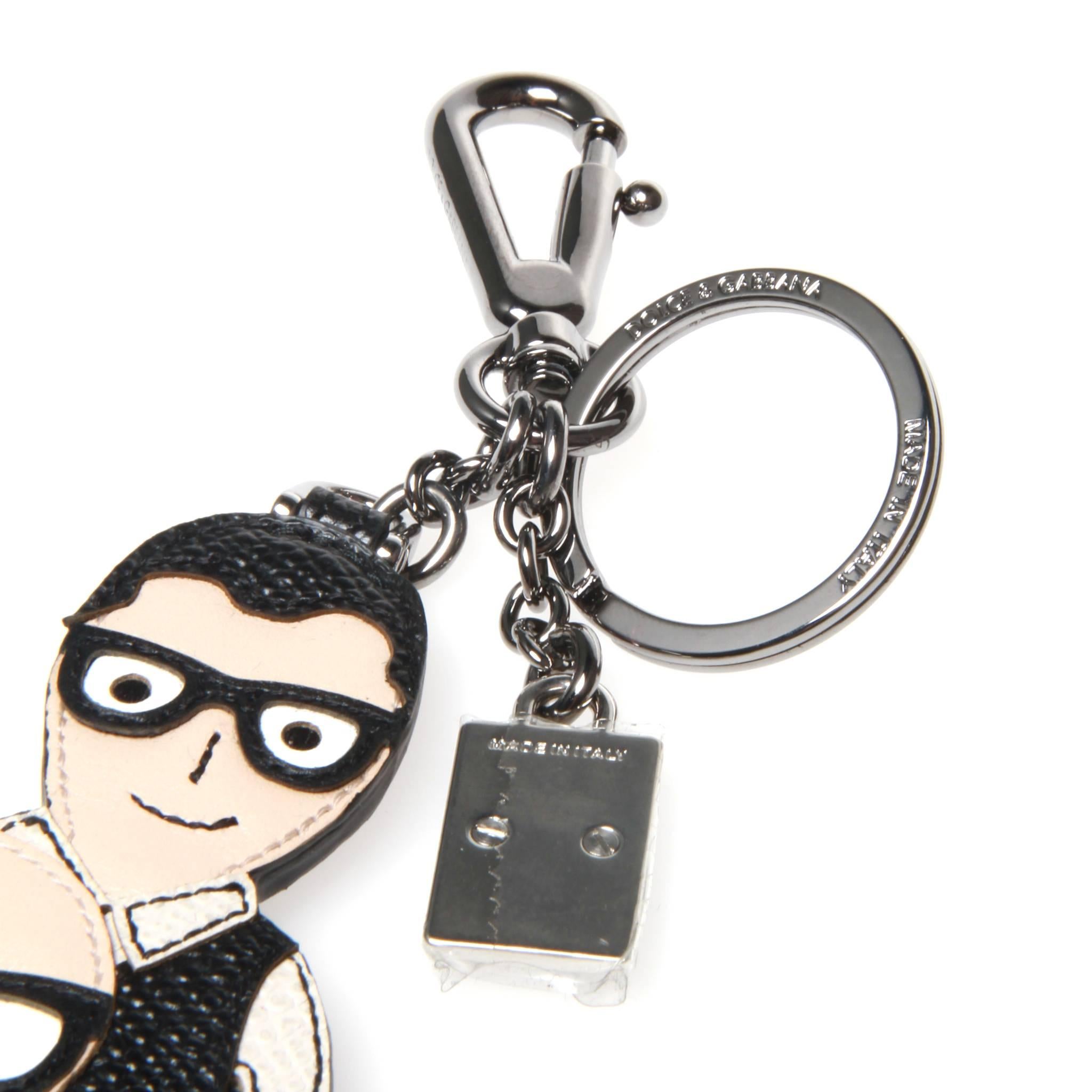 Dolce and Gabbana key ring featuring dauphine calf leather graphic and accented with silver-tone metal clasp and ring with two-tone brand plaque. 

Made in Italy.
