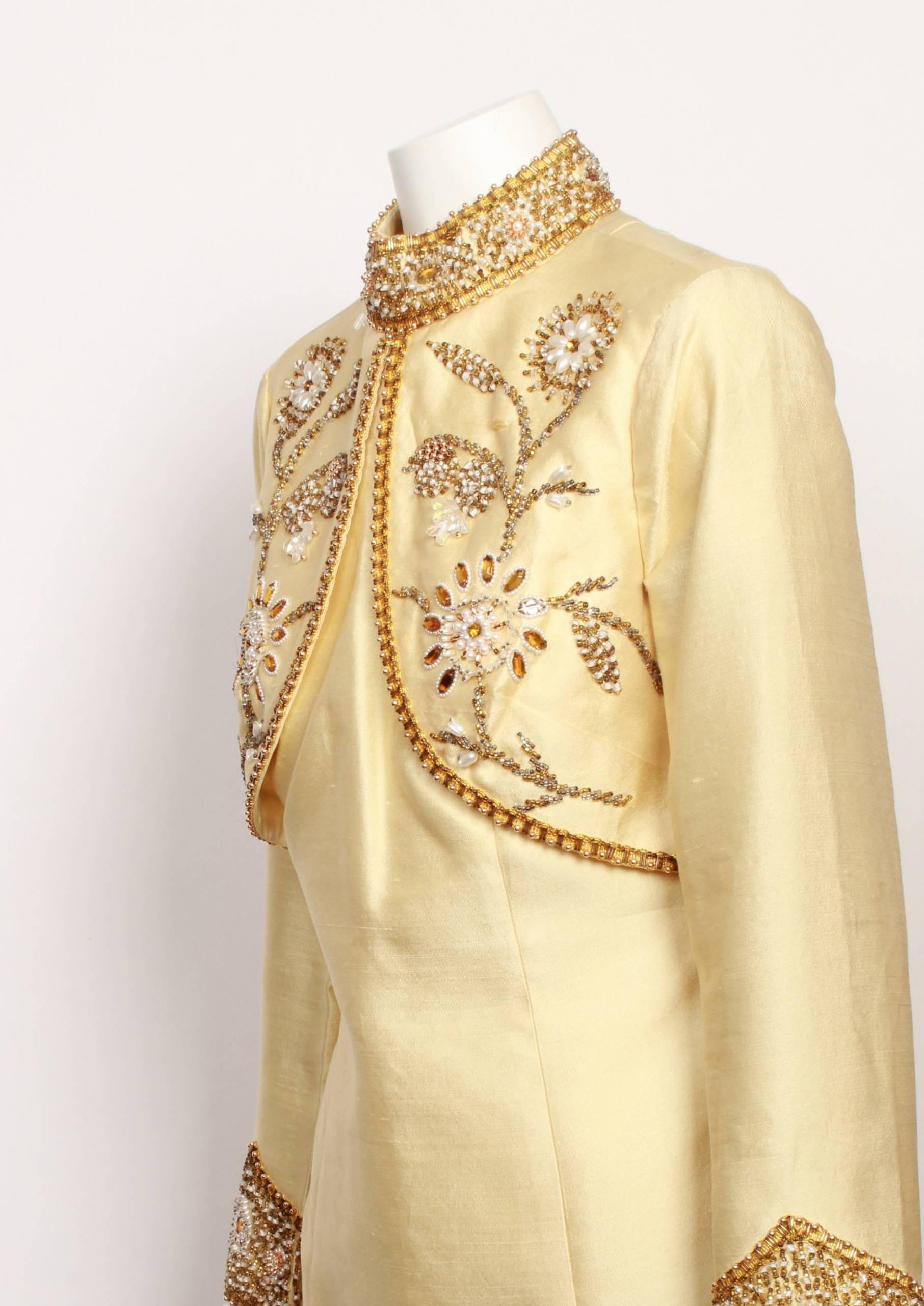 Stunning 1960's vintage jewel encrusted pale gold A-line mini dress made from 100% silk dupion. Beautiful floral hand beading in gold and white on bodice overlay and heavy encrusted beading on collar and sleeve hem. Back zipper closure and fully
