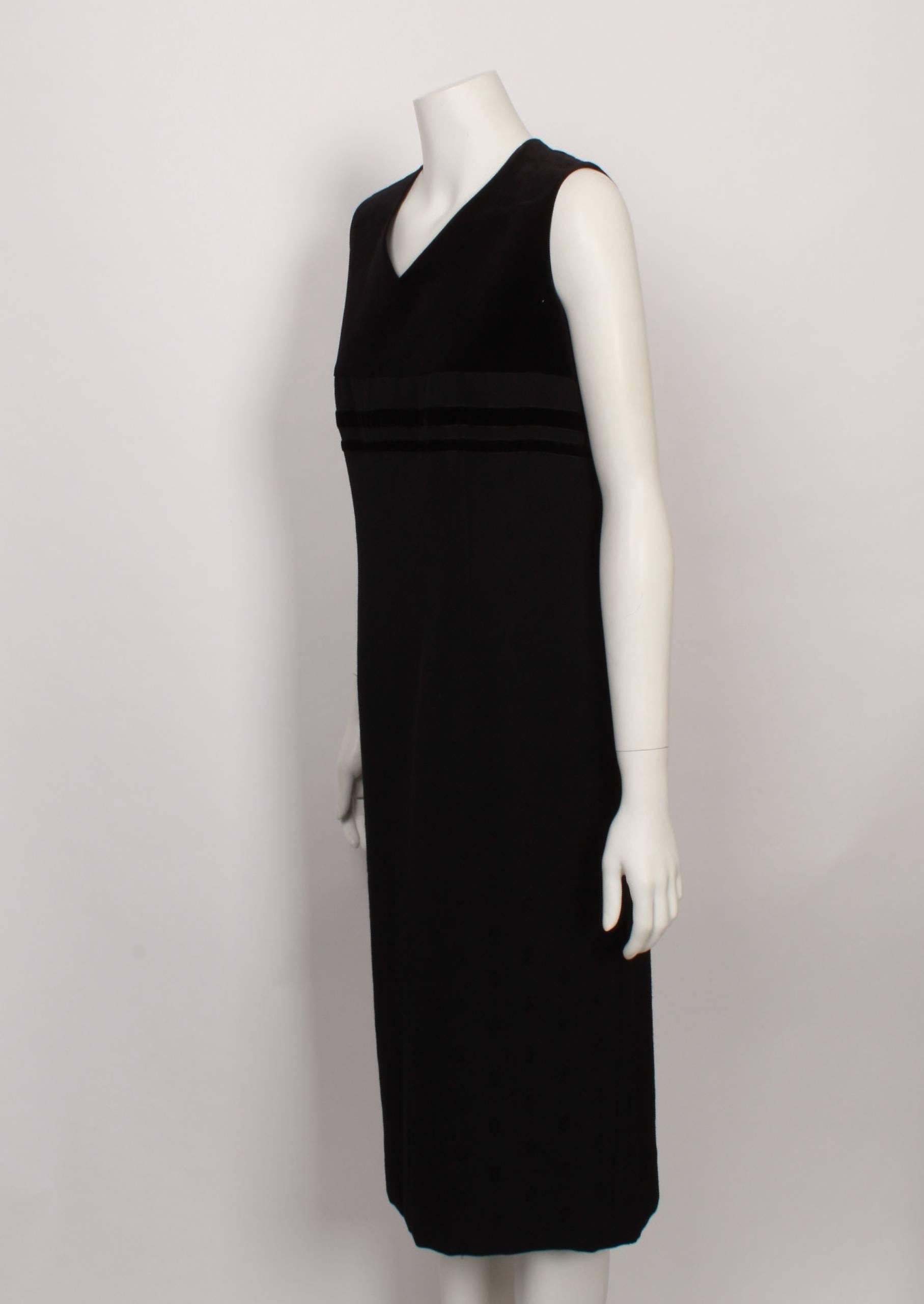 Robe de Chambre by  Comme des Garcons sleeveless shift dress features a cotton velvet empire-line bodice with velvet ribbon trims and classical V neckline. The main dress is made from wool twill with a small self all-over pattern. The back has a