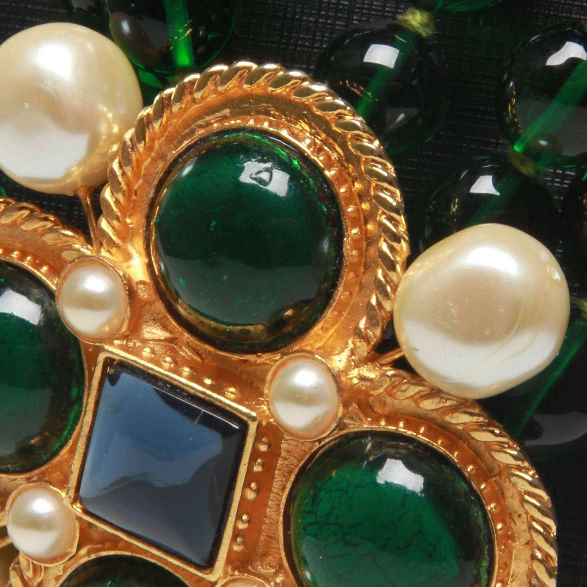 A pristine vintage style Chanel necklace with a gripoix brooch features emerald and blue poured glass detail with pearl throughout the outside.

Fastener: Pins at the back.

Featuring x4 green giproix stones, x4 pearl with blue stone.

Highly