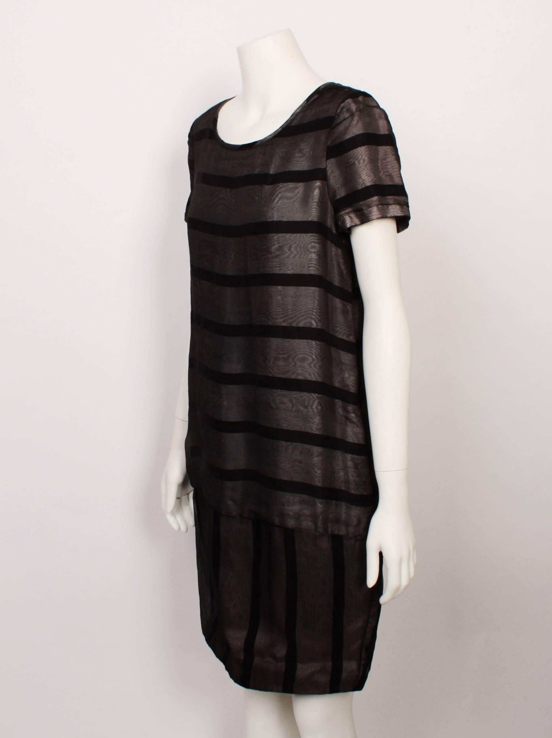 Alexander McQueen striped organza shift dress features a scooped neckline and a short sleeve.
 Sheer organza overlay is mounted over grey and black striped base fabric. Stripes run horizontally across the main dress and vertically at the hem panel.