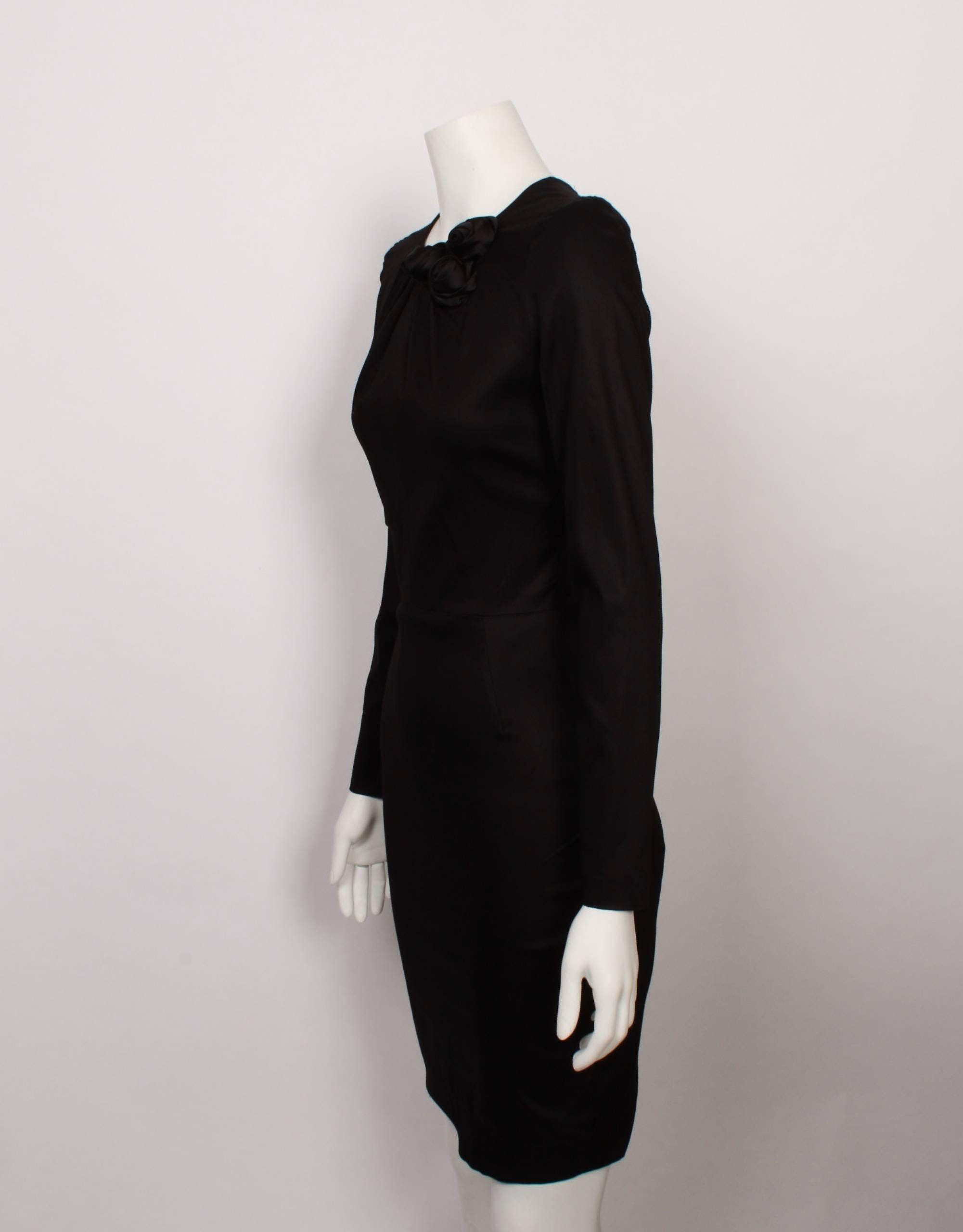 Stunning and timeless black Valentino fitted shell dress features a beautiful rosette corsage detail and a delicate spray of tucks at the front neckline, and a long fitted sleeve. This dress would suit any occasion, and its classic styling will