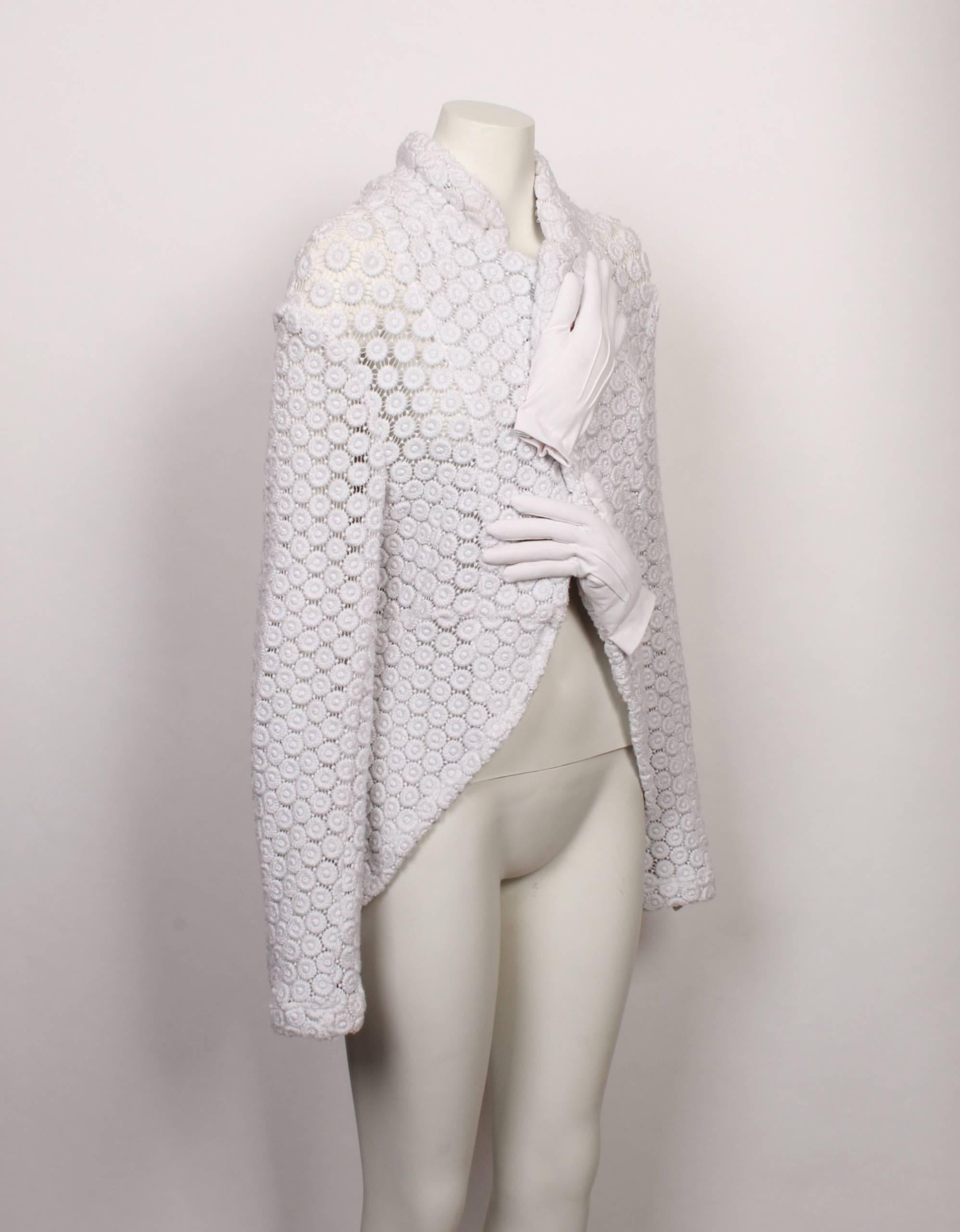 Iconic COMME des GARÇONS white knitted tailcoat with padded hand attachments from the 2007 Autumn/Winter collection.
Textured sheer white daisy Guipure lace, this rare jacket is a collector's item. 
Pull on with no fastenings, turn back collar and