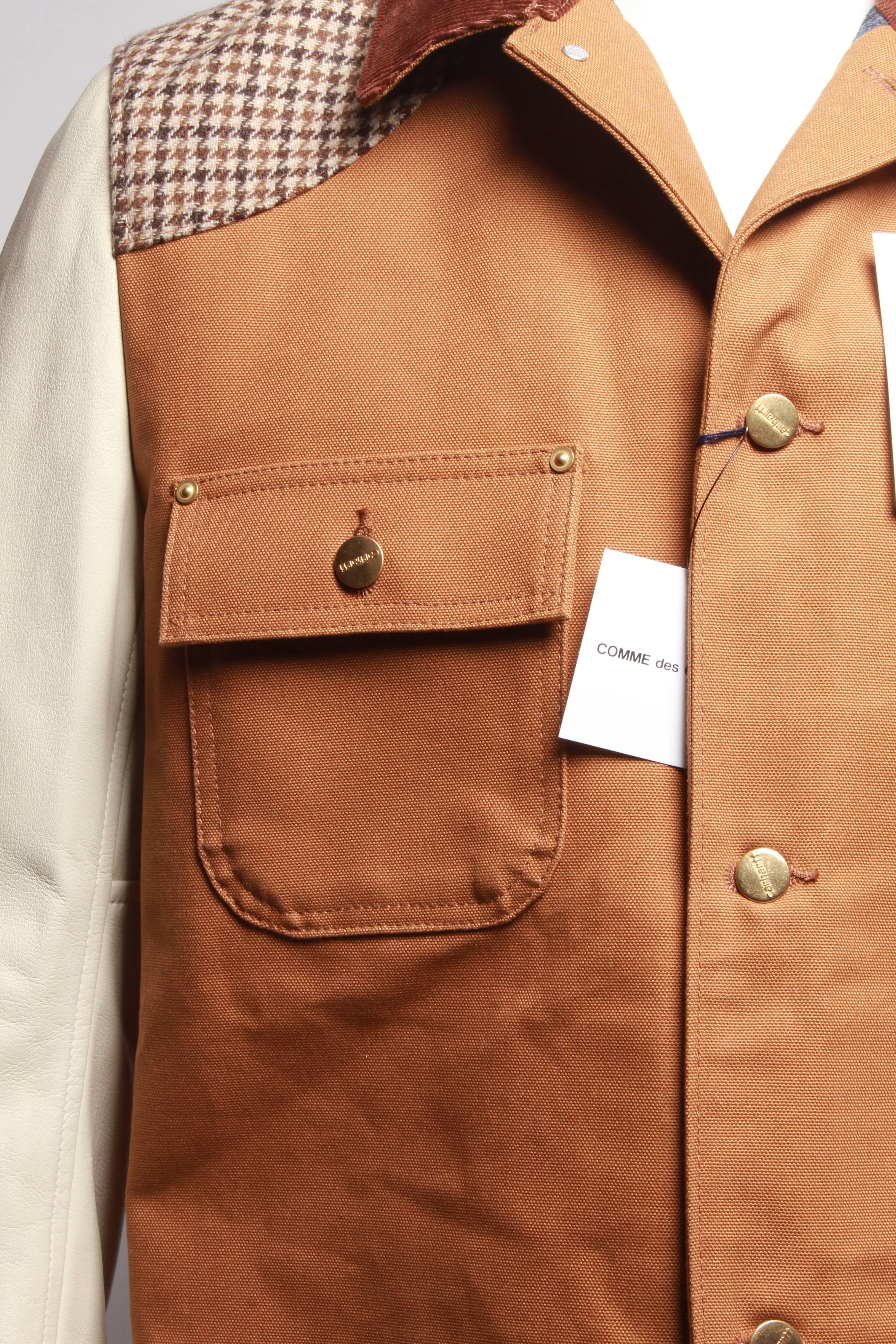 Patchwork chore coat from Junya Watanabe MAN in collaboration with Carhartt in Brown and Off Beige. Spread collar. Full button front closure. Branded buttons. Multiple patch pockets at front. Woven Carhartt patch. Interior pocket with Velcro