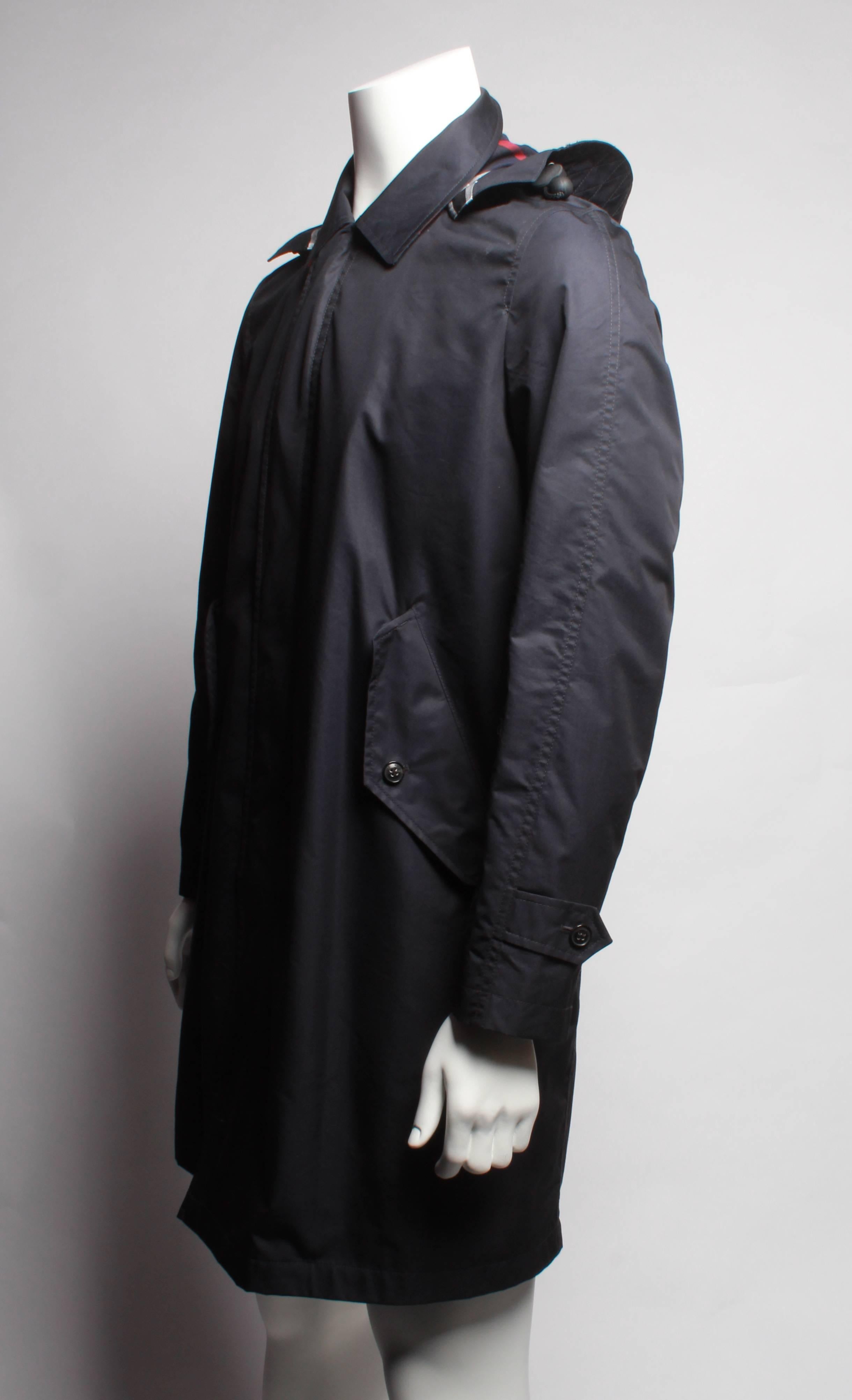 A showerproof car coat in a resin-backed cotton blend. Engineered for changeable weather, the coat features a protective hood that can be detached on dry days. NTW, never worn. 

Size:  50
Outer: 65% cotton, 35% polyamide
Check undercollar: 100%
