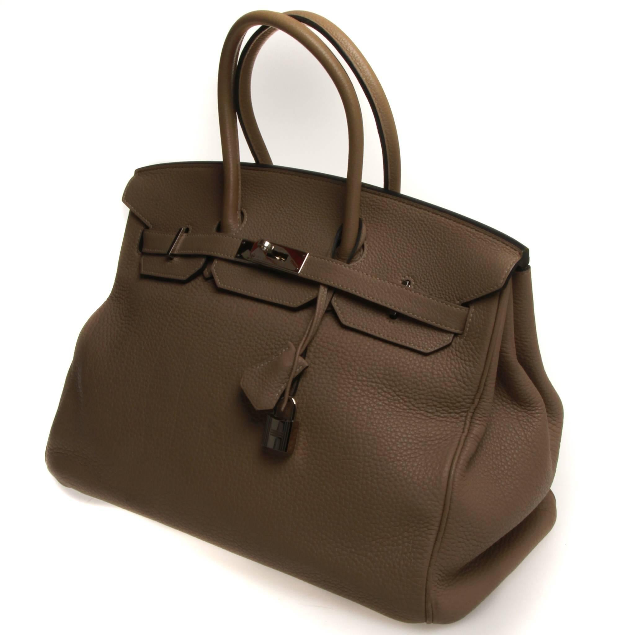 Etoupe Togo leather Hermès Birkin 35 with palladium-plated hardware, dual rolled handles, tonal leather interior, dual pockets at interior walls; one with zip closure and flap with turn-lock closure at front. Blind stamped O in a square denoting