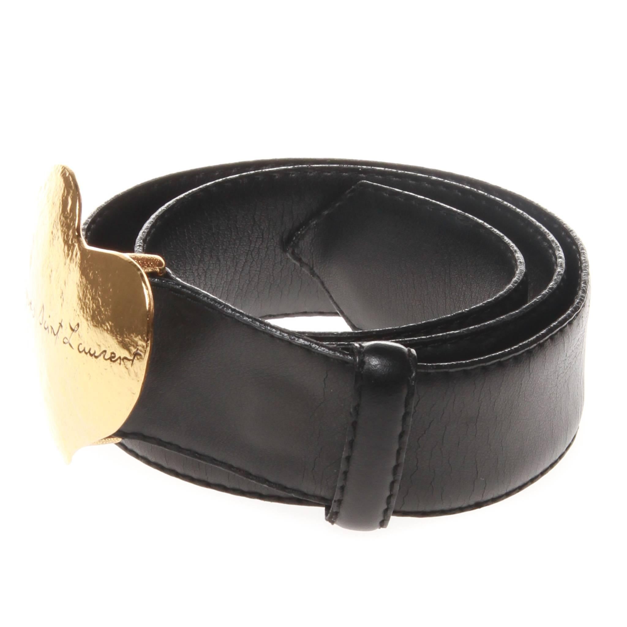 Vintage Yves Saint Laurent black leather belt featuring a gold tone heart buckle. Buckle is engraved with 'Yves Saint Laurent' in cursive script. It has the original 5 belt holes and is 71cm from buckle to furthest hole.  Made in France.