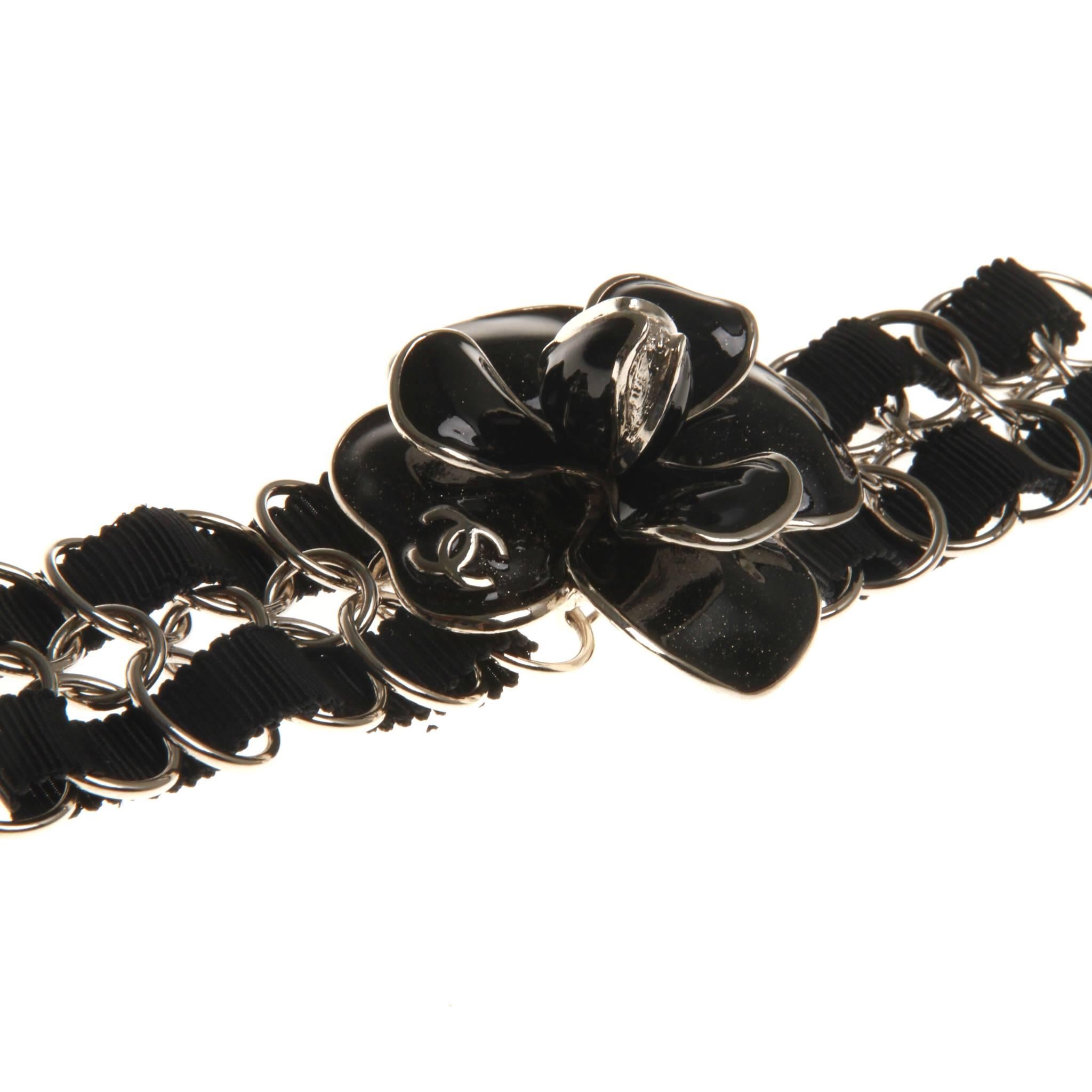 From the Spring 2008 Collection. Black shimmery Chanel Enamel Camellia Bracelet with silver-tone hardware, interlocking CC logo detail, chain-link detail and lobster-clasp closure.

With box and jewellery pouch. 