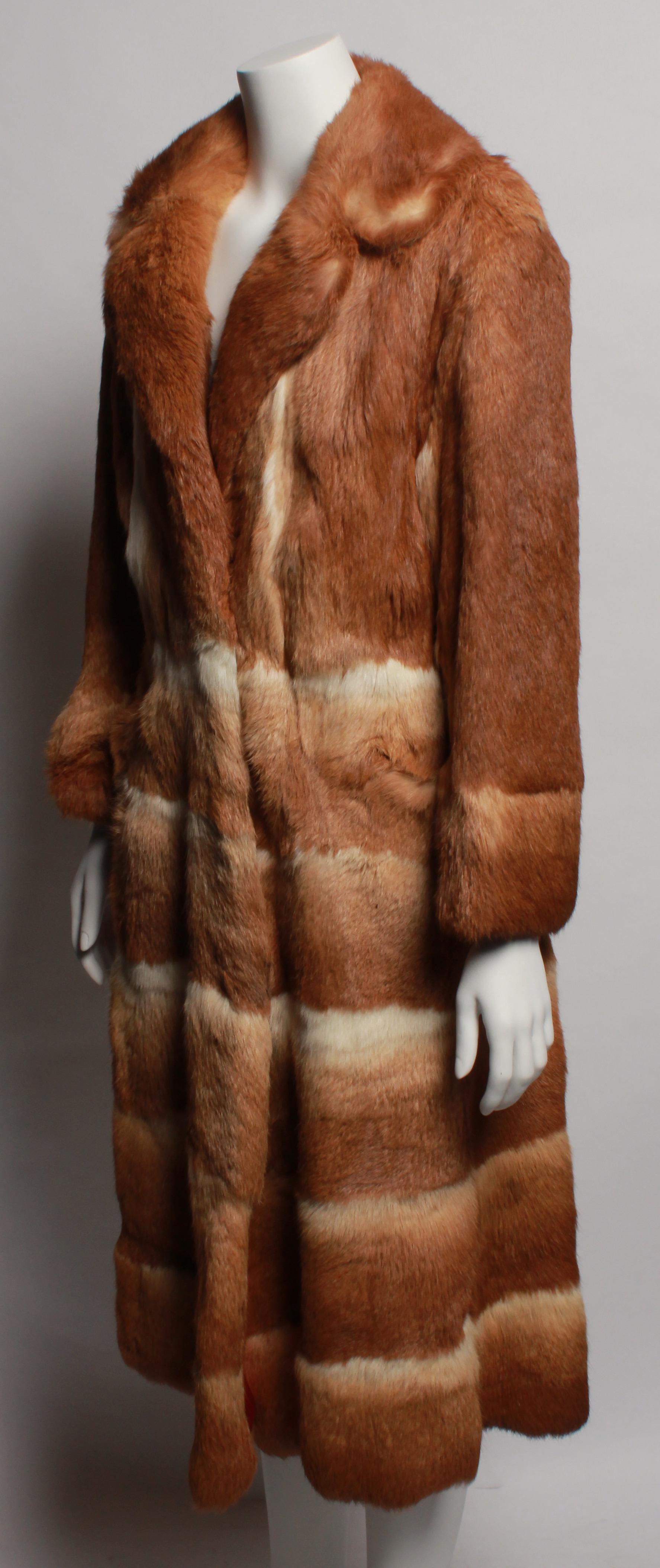 Vintage Lapin Fur coat with copper coloured lining. This full length coat features three fastening hooks and two side pockets. The coat falls at a wonderful A-line and has a fur half belt on the back. This coat is in near perfect condition with