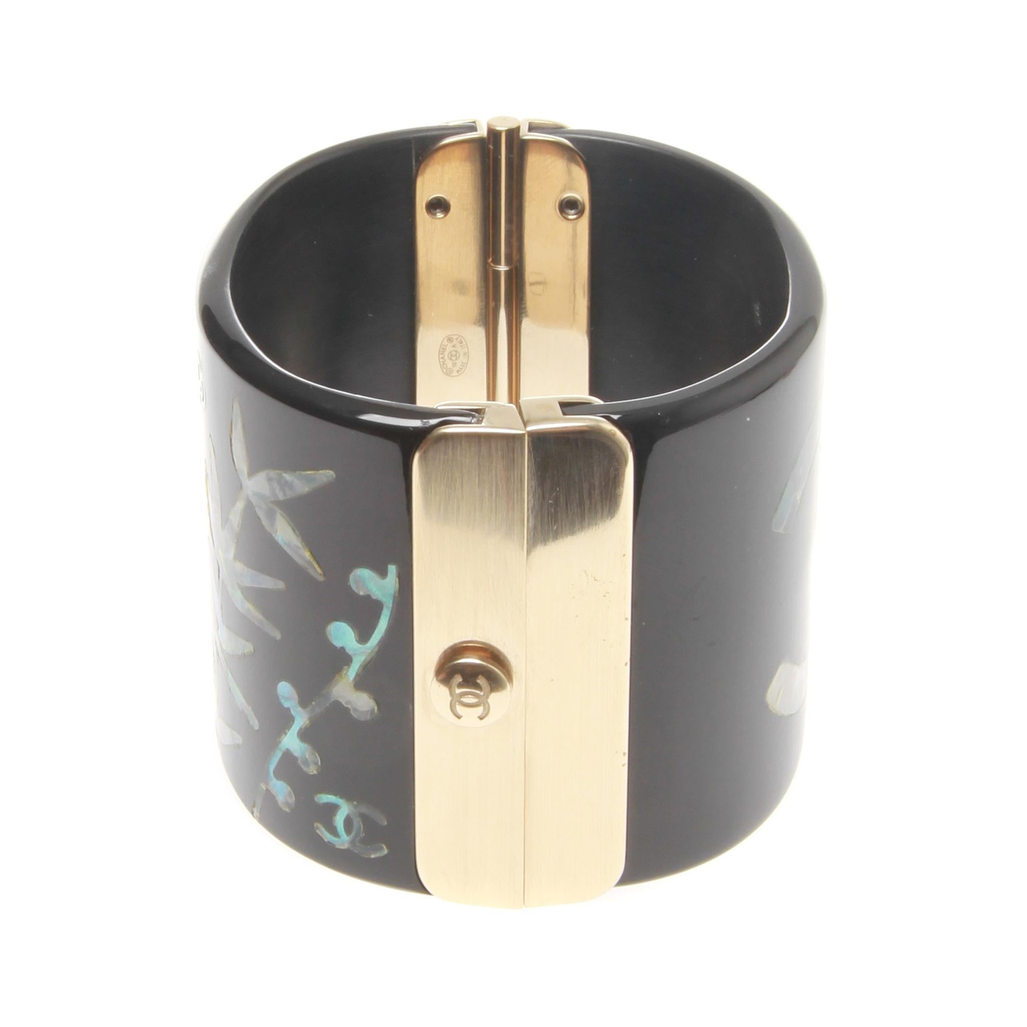 Chanel Black Resin Cuff Bracelet Mother Of Pearl Bird Inlay Signed

One of a kind signed mother of pearl bird black resin cuff by Chanel .
It features a mother of pearl bird inlay and iconic CC logo signed embellished black resin cuff bracelet, and