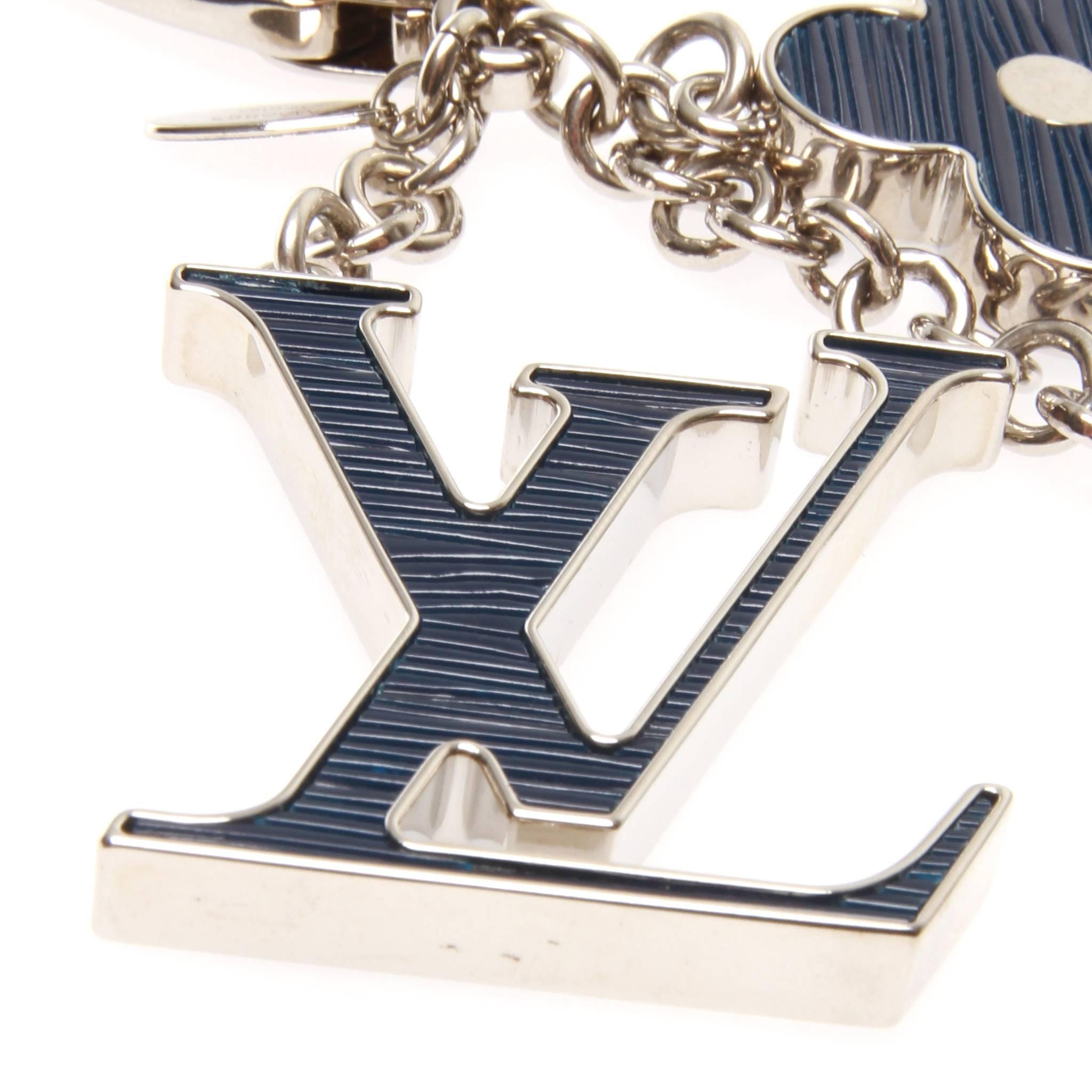 Louis Vuitton Fleur D'Epi  bag charm in blue. Featuring the iconic monogram shapes formed of palladium-finish brass and inlaid with resin, this bag charm is simple and effective. The inlaid resin is set to imitate the appearance of LV's Epi leather