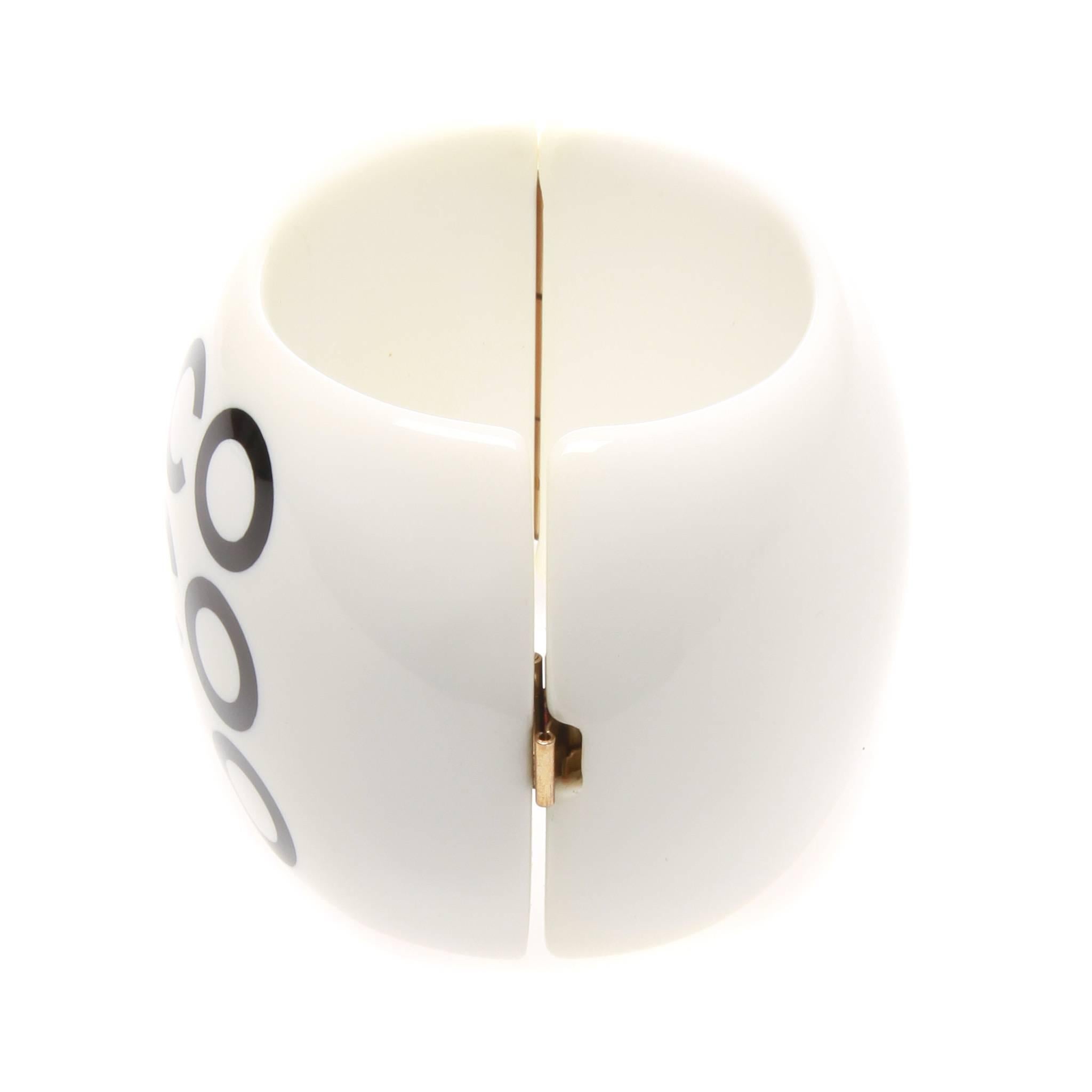 FINAL SALE
Madam Virtue & Co

Chanel cuff from the Spring 2011 ready-to-wear collection. Formed of white resin with black COCO type accents the cuff is a modern statement from an iconic era for the house. Hinged at one side, the cuff is opened and