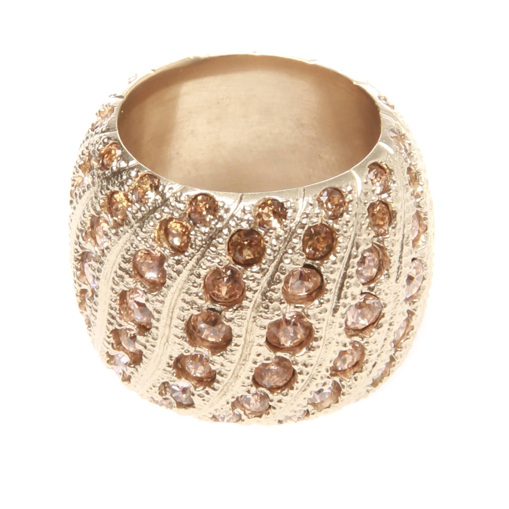Chanel paved champagne Swarovski crystal gold-tone ring from the Cruise 2016 collection. Beauitful wide-set band with continuous curving lines of bright cut crystals.

Date stamp reads B16 C

Ring Size: 54
US Size: 7
Wide Size: 3/4