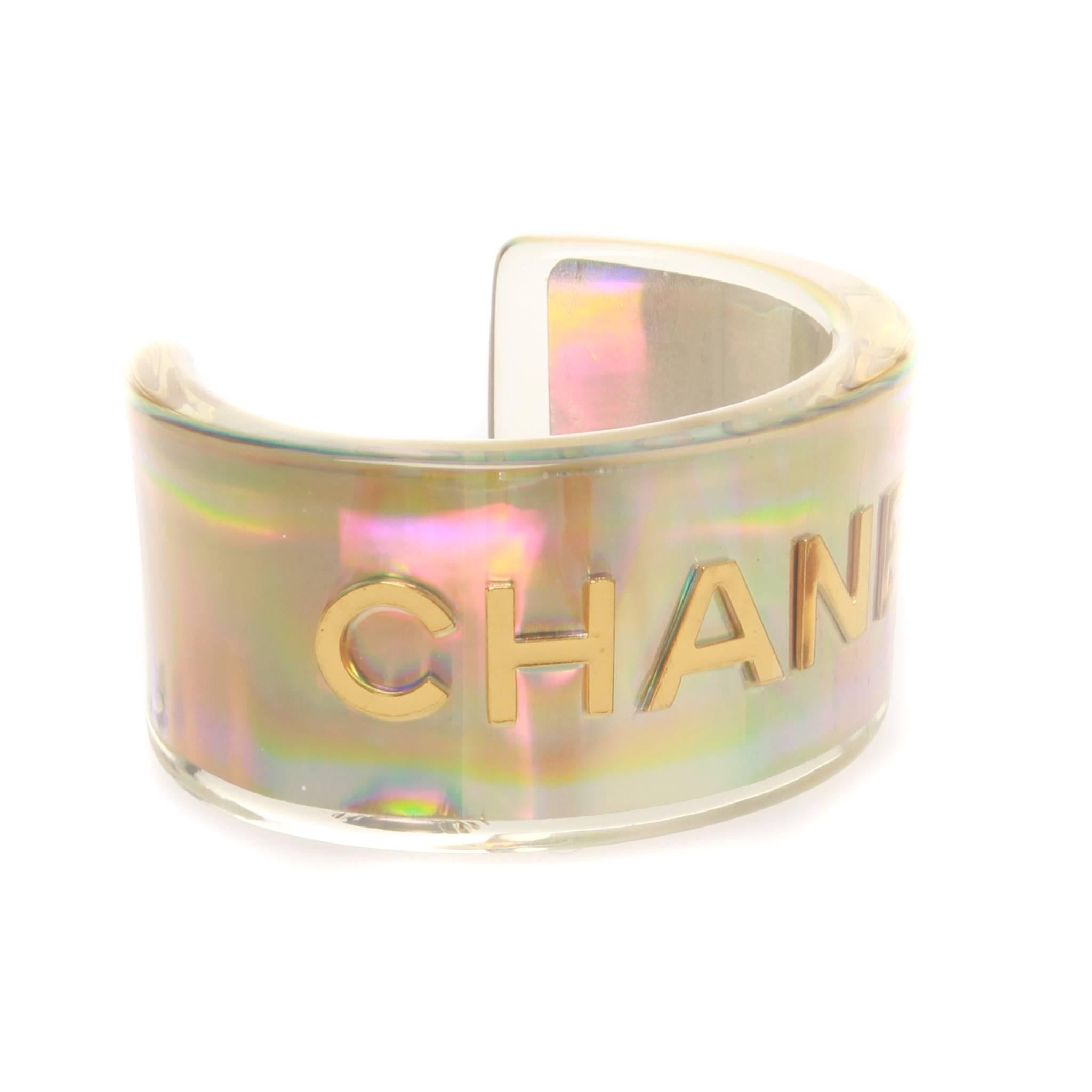 Chanel cuff from the Spring 1997 ready-to-wear collection. Crafted from resin with a golden-hued holographic finished and sporting a bold gold CHANEL type, the cuff is designed in a cool and easy, open style. 

Stamped: 97 CC P 
Comes with authentic