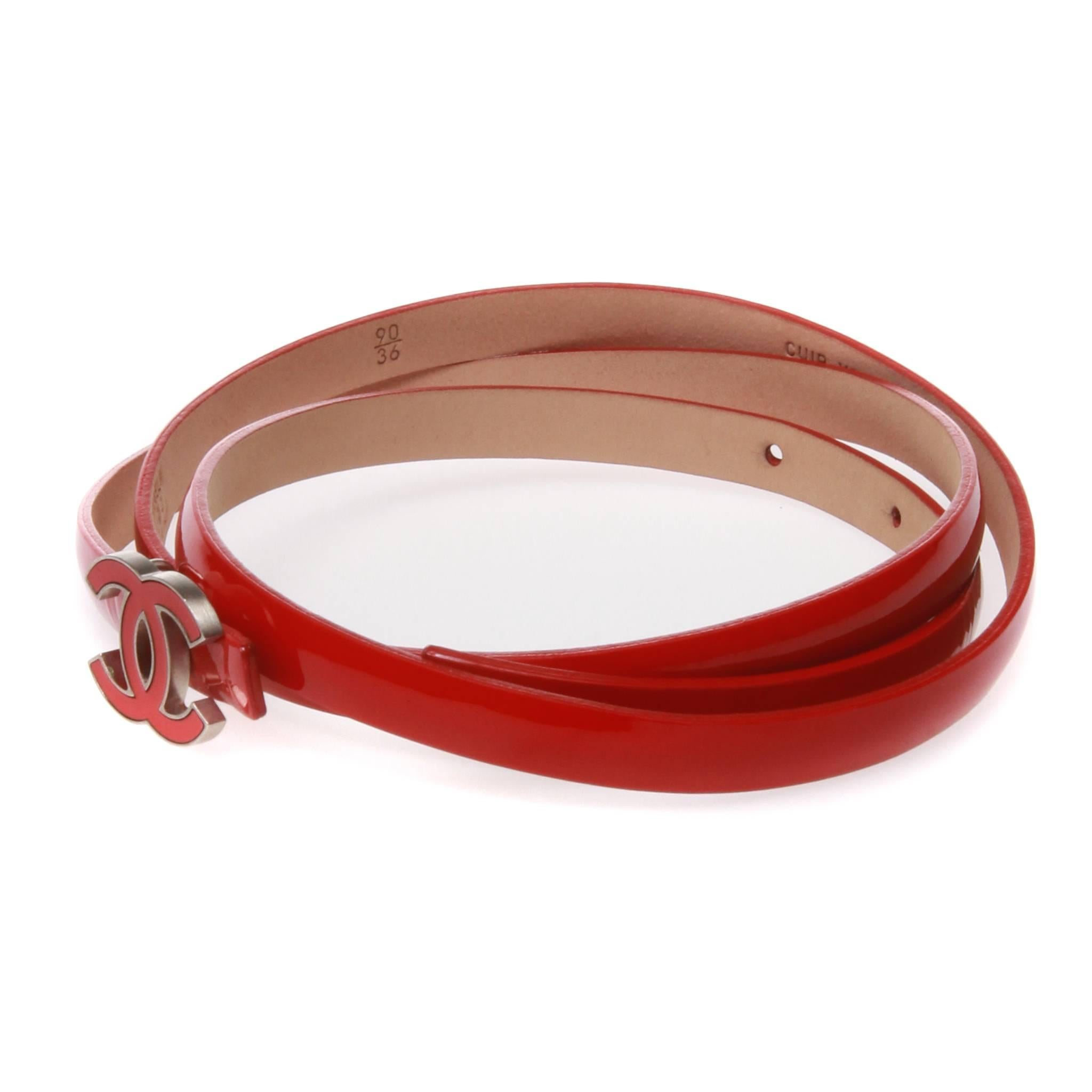 Red patent leather Chanel belt from the Cruise 2012 collection with interlocking CC logo accent at front. CC logo doubles are belt buckle for peg-in-hole closure. Includes authentic and original box and dust bag. 

Designer size 90/36.

Stamped B12