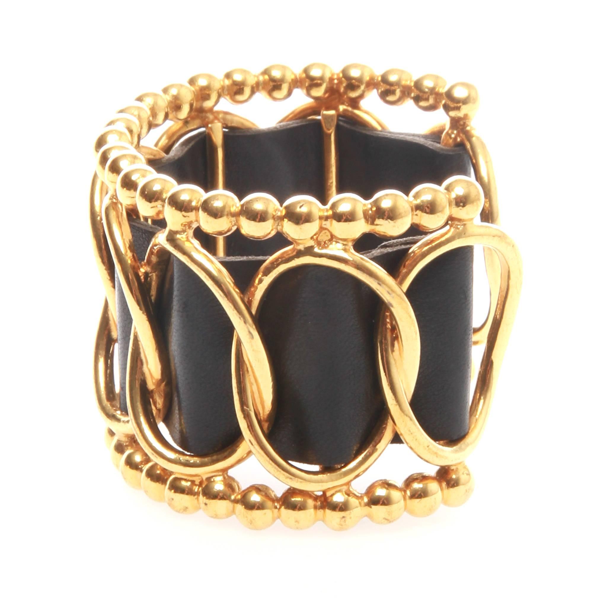 Vintage Chanel cuff in intricate gold-tone metalwork woven with a thick lambskin leather detail. The bracelet is formed as an open cuff with provides for ease of wear. Vintage and edgy design redresses the classic woven chain strap of Chanel bags.