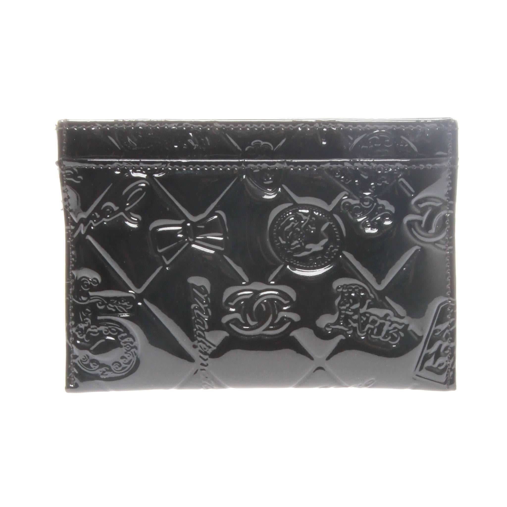 Chanel cardholder in black patent calfskin featuring an embossed lucky symbols quilted pattern featuring an array of iconic Chanel related icons.

Features two card slots to the front and a slot from receipts at back. 

Comes with authentic and
