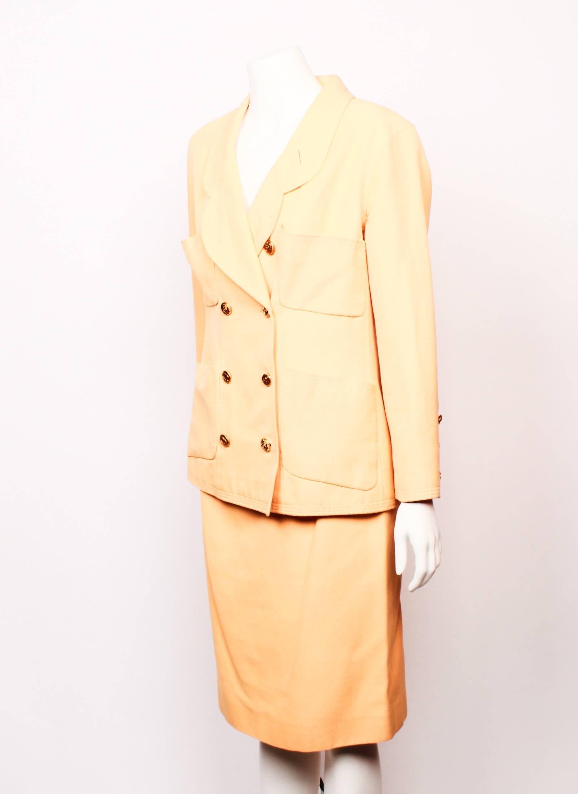 Beautiful two piece Chanel Boutique straight pencil skirt and double breasted jacket suit ensemble in apricot cotton faille.
The jacket features a lovely soft petal shaped lapel and four patch pockets. Double breasted closure and cuffs have iconic