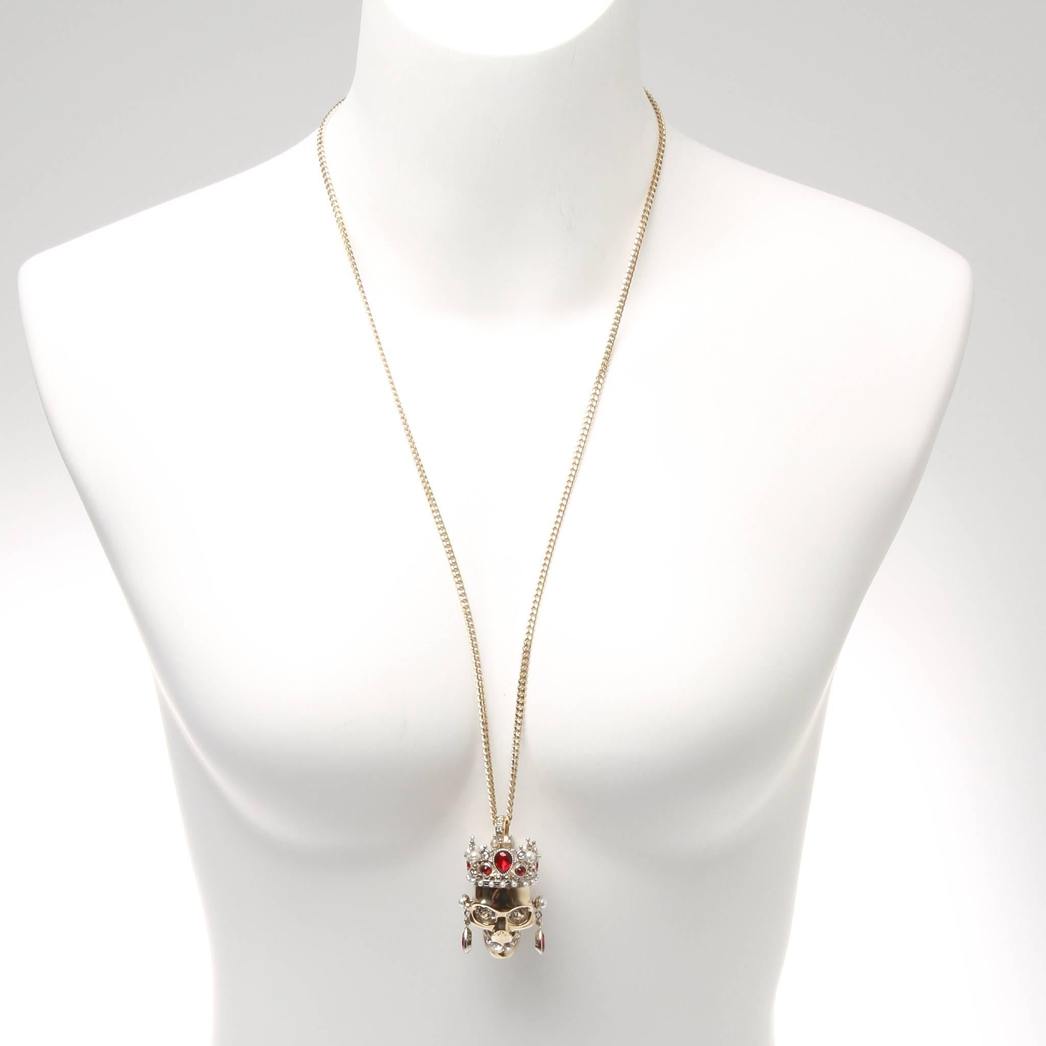 Silver-tone brass and crystal crown skull pendant necklace from Alexander McQueen featuring ruby red Swarovski crystals, faux pearls and an engraved logo charm. Opera length chain.

With original box and jewellery pouch. 