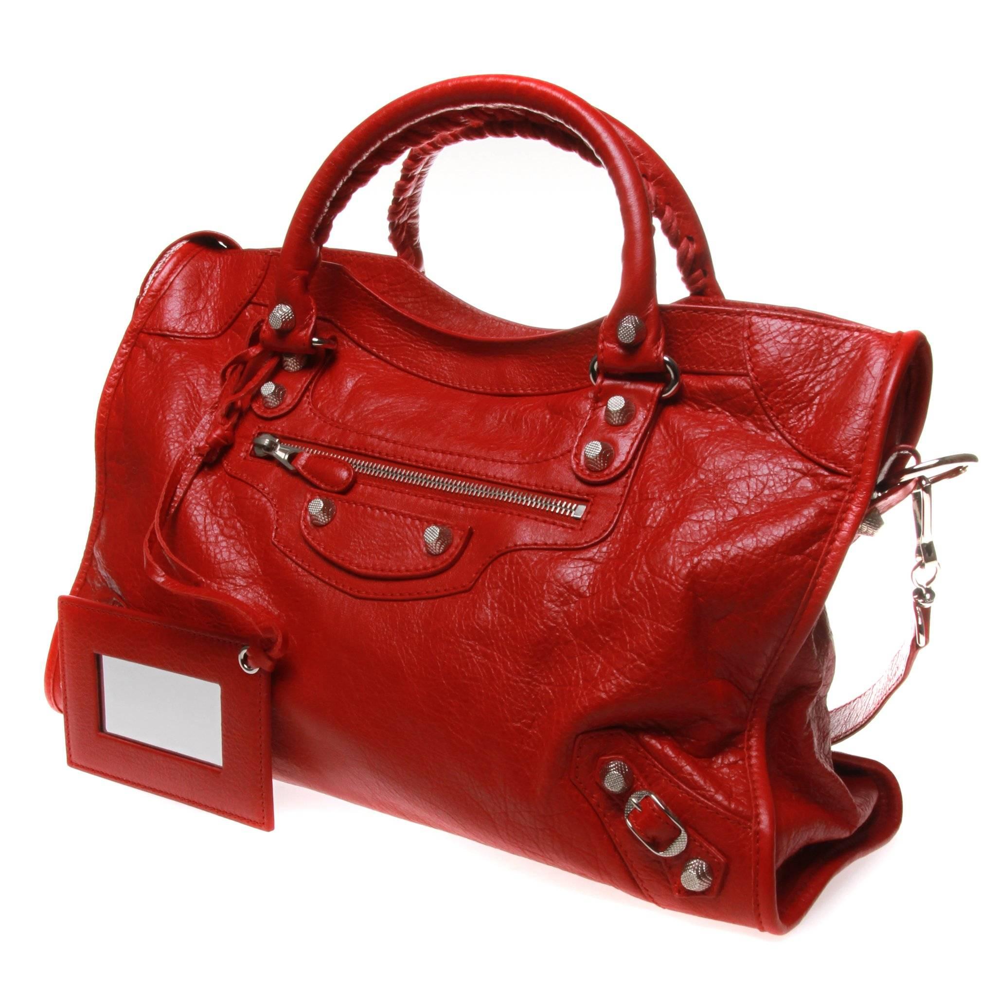 Red Arena leather Balenciaga Motocross City bag with Giant 12 silver-tone hardware, dual rolled handles with whipstitch accents, detachable flat shoulder strap, single exterior zip pocket, stud and buckle embellishments at front, black woven lining,