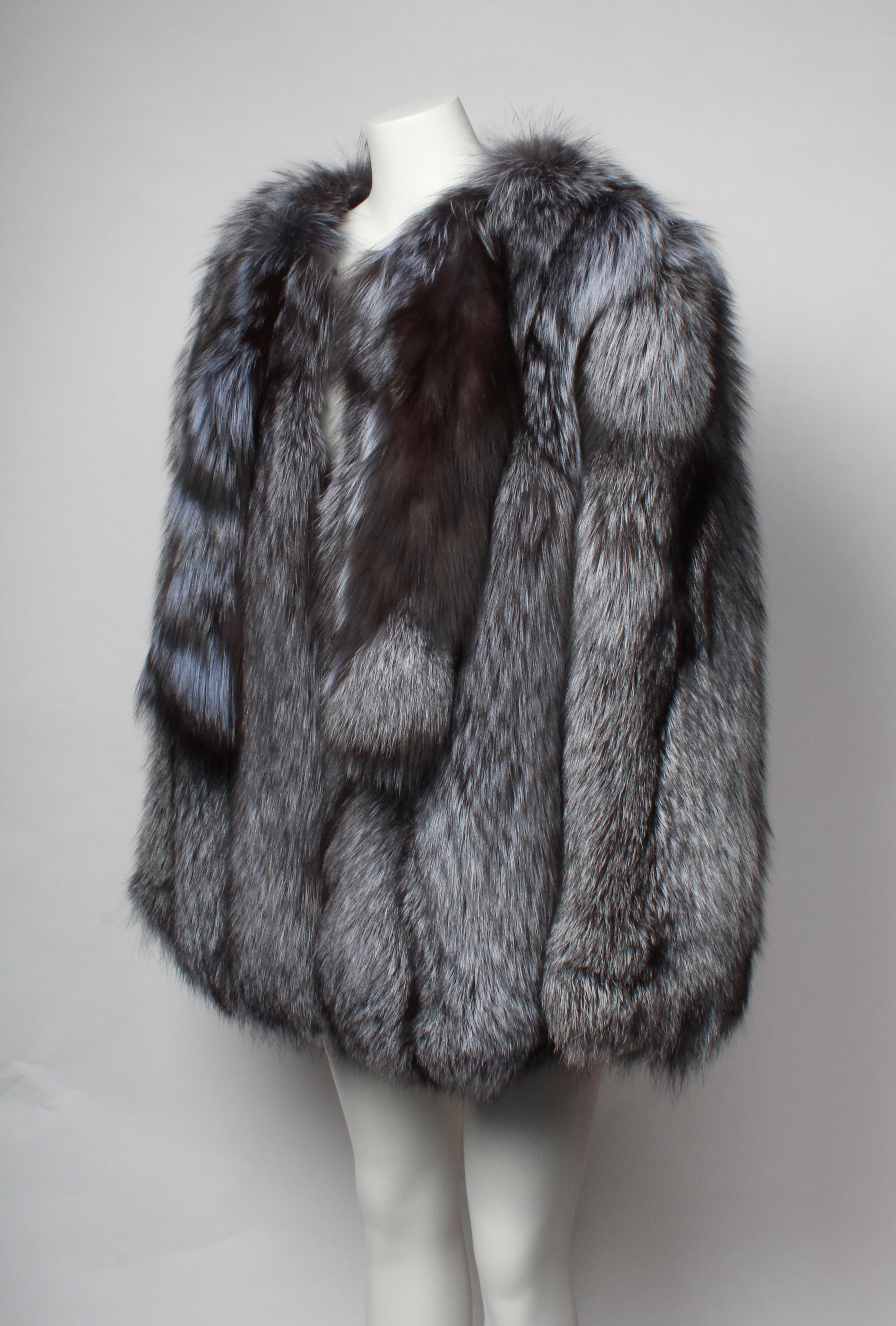 Made in Scandinavia, this is an incredible Blue Silver Fox Coat. The coat is over sized and fits a medium to large. The coat features neckties dyed lilac and five fastening hooks.