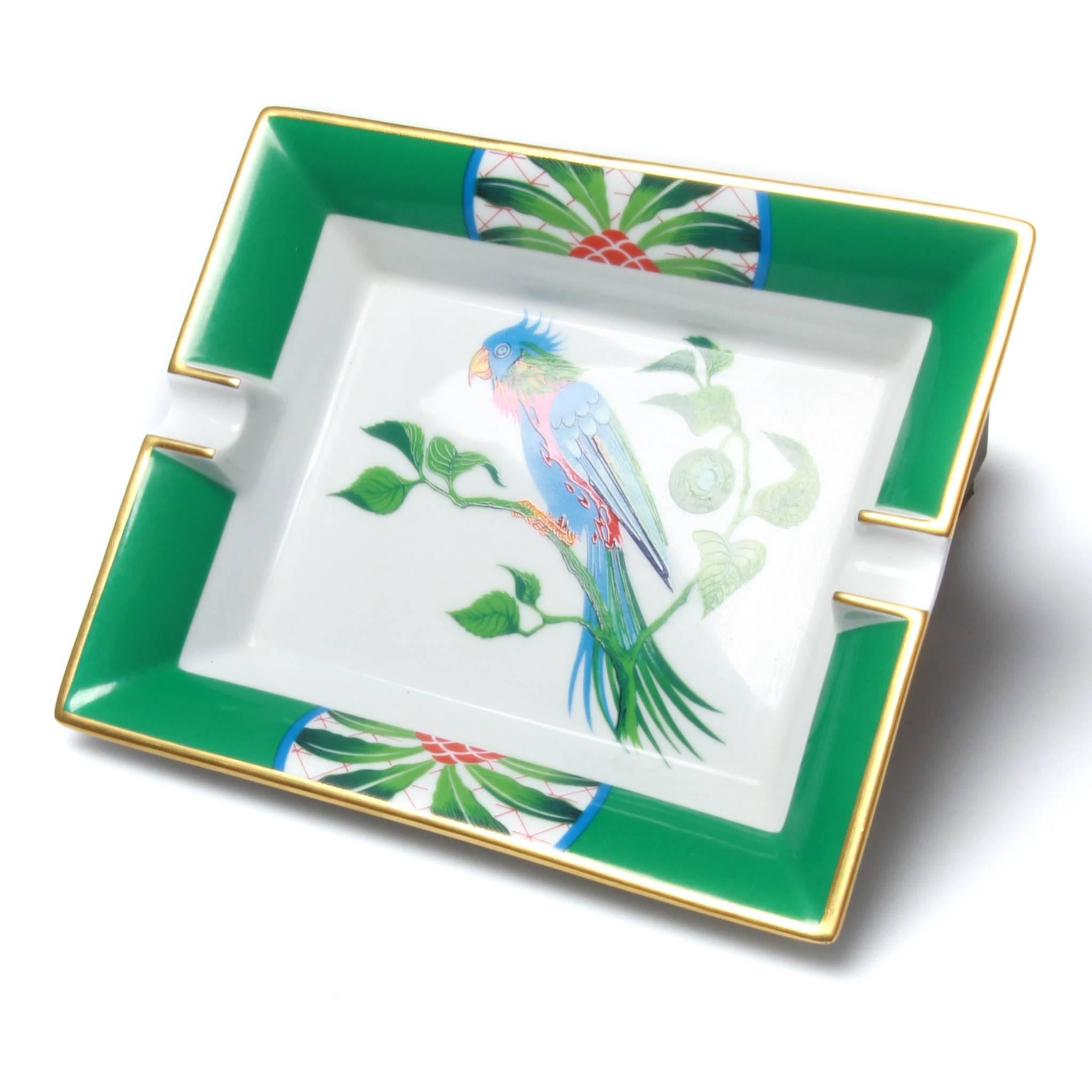 Hermes ashtray featuring a parrot agaisnt a green and white ground. Natural suede base and Hermes Paris printed on bottom.  