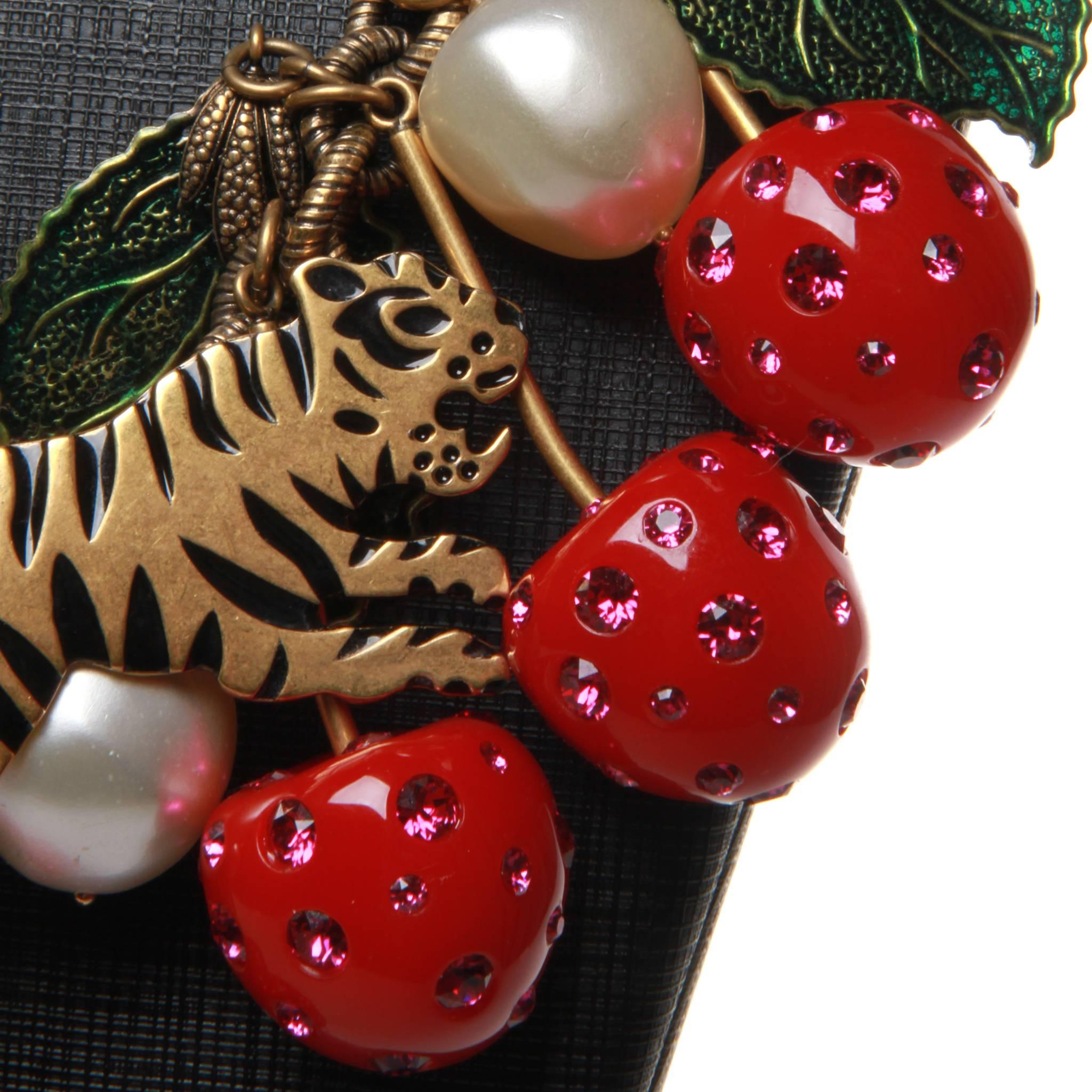 Gucci statement necklace featuring tigers in gold/bronze tone metal amongst painted foliage, faux pearls and pink Swarovski crystal encrusted red resin cherries. Lobster closure at back.

Adjustable 30-40cm