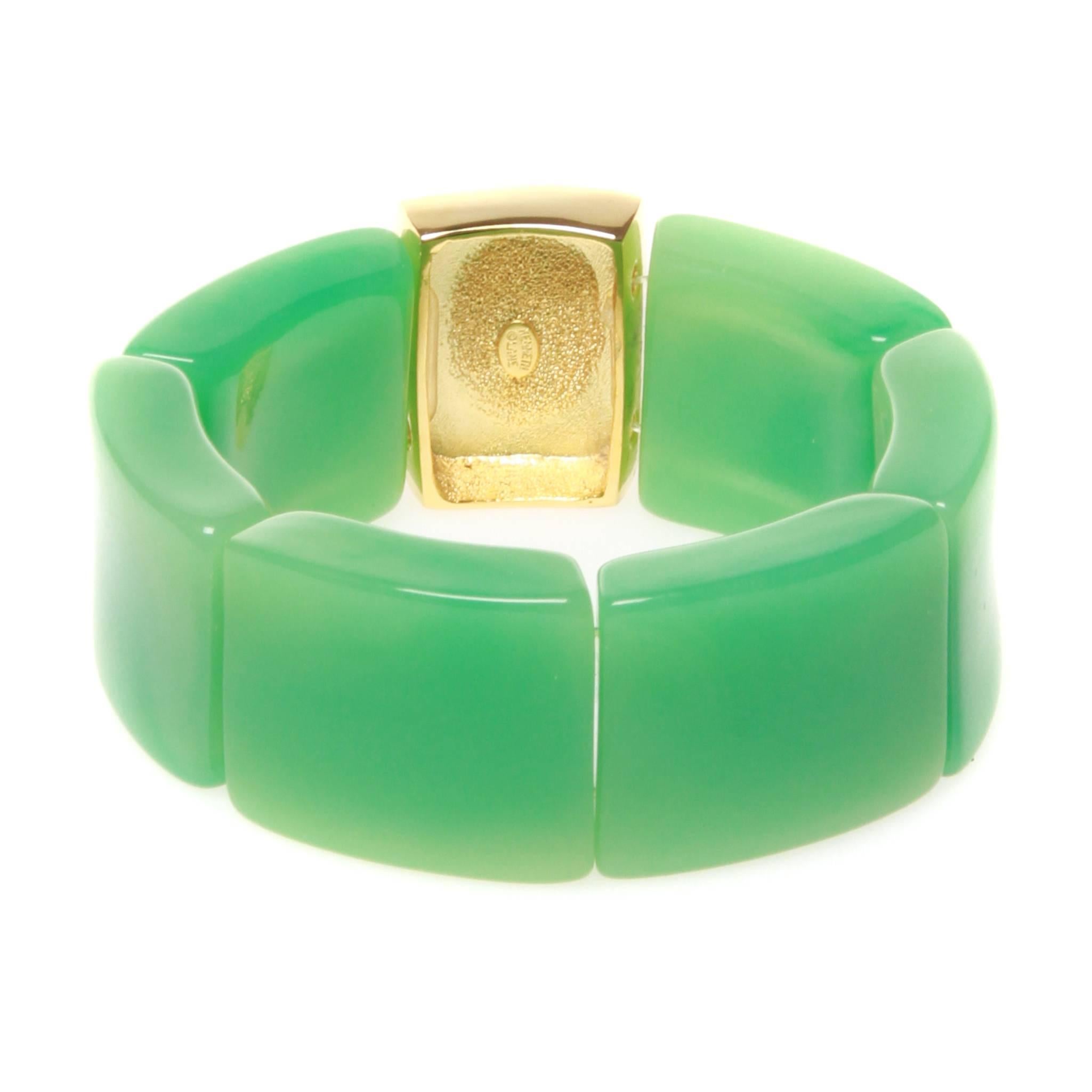 Vintage Kenneth Jay Lane cuff in green resin featuring a central gold-tone segment set with an orange oval stone. Brand stamp on metal.