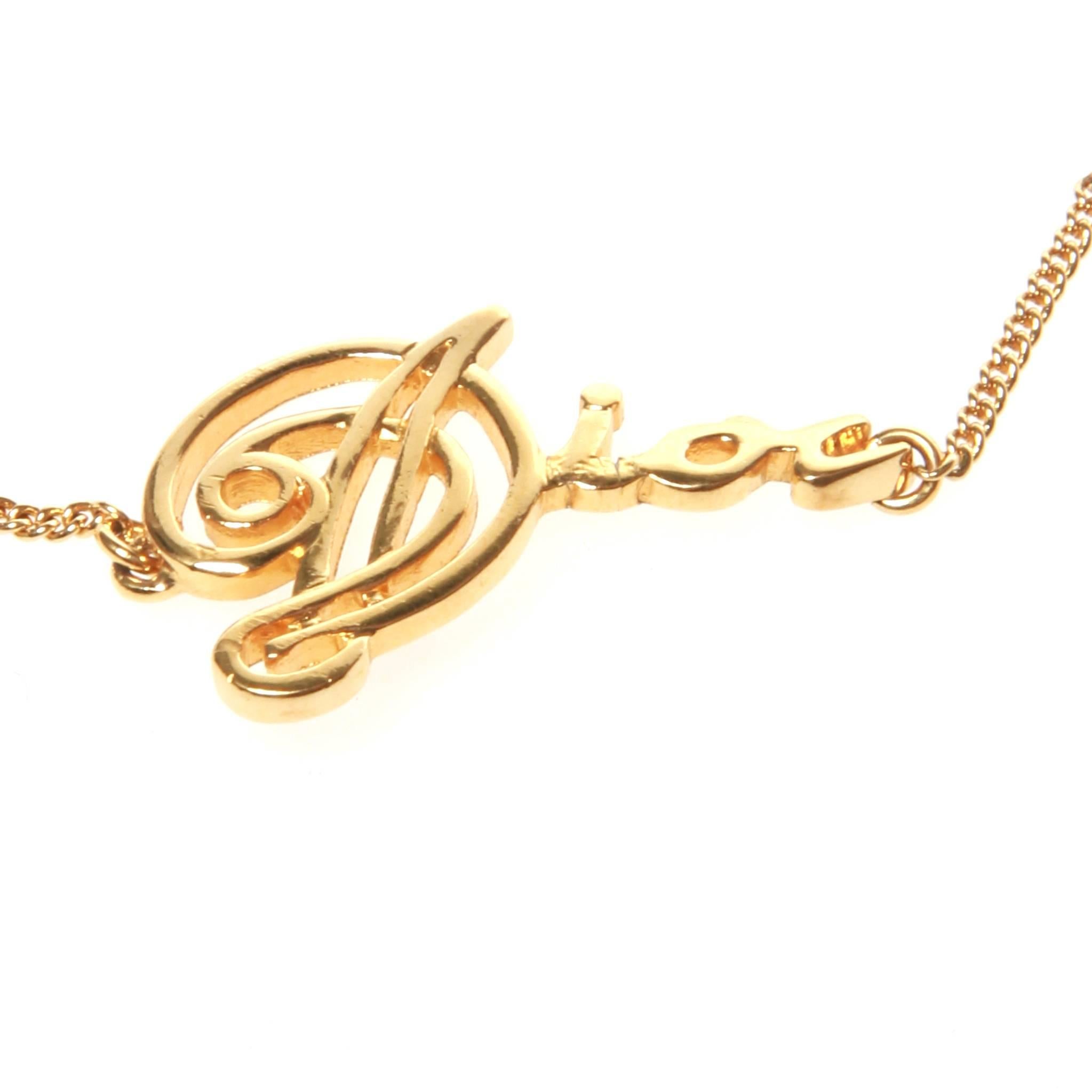 Christian Dior gold bracelet featuring 'Dior' in cursive font on a thin chain. Size adjustment and lobster claw fastening with Dior stamped 'CD' at the end. 
