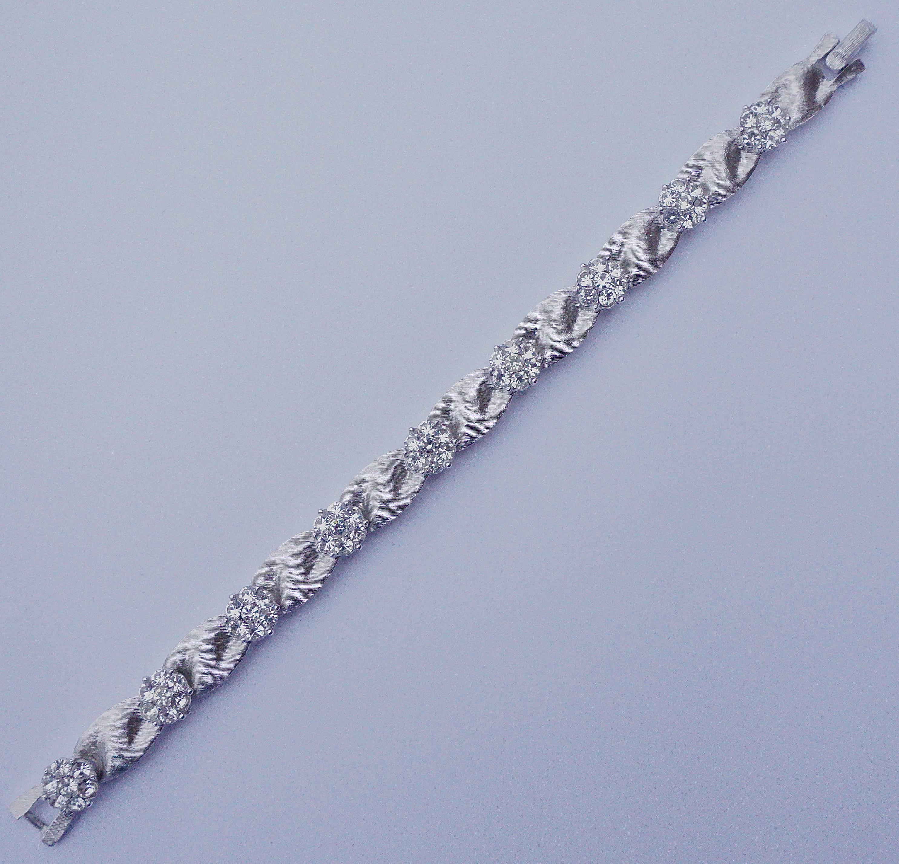 Trifari brushed silver plated ribbon design bracelet, length 18.5cm / 7.3 inches by width 9mm / .35 inch. This beautiful vintage bracelet is from Trifari's Birthday Collection, diamond rhinestones for April. Circa 1960s.

This is a stunning vintage