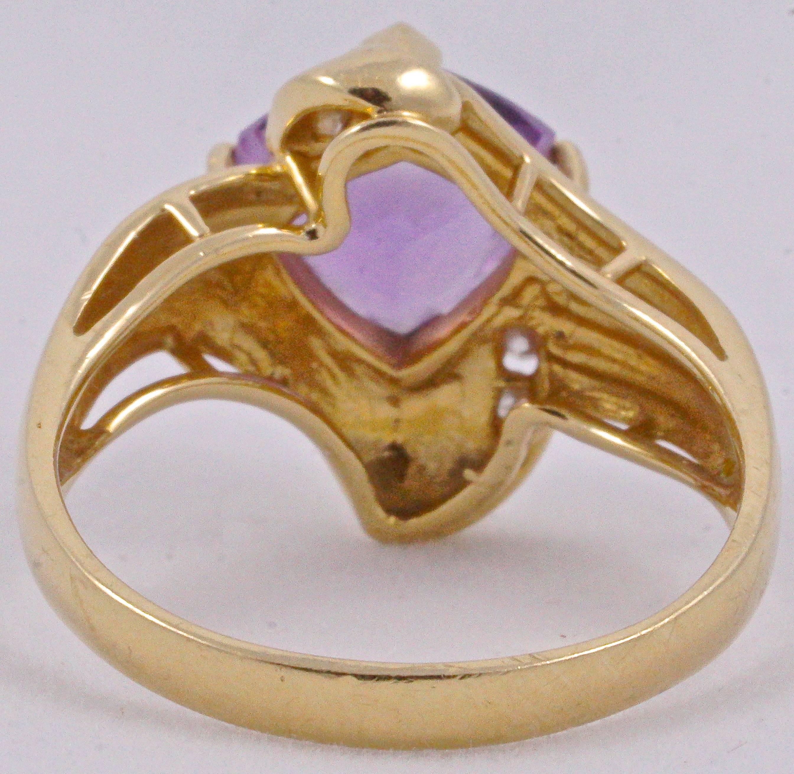 14K gold dress ring with a faceted amethyst and four channel set diamonds, stamped J&C, 14KP.  The setting is plain and shiny on one side, and has a ridged pattern on the other. Ring size UK O 1/2, US 7 1/4, inside diameter 1.9cm / .75 inch. The