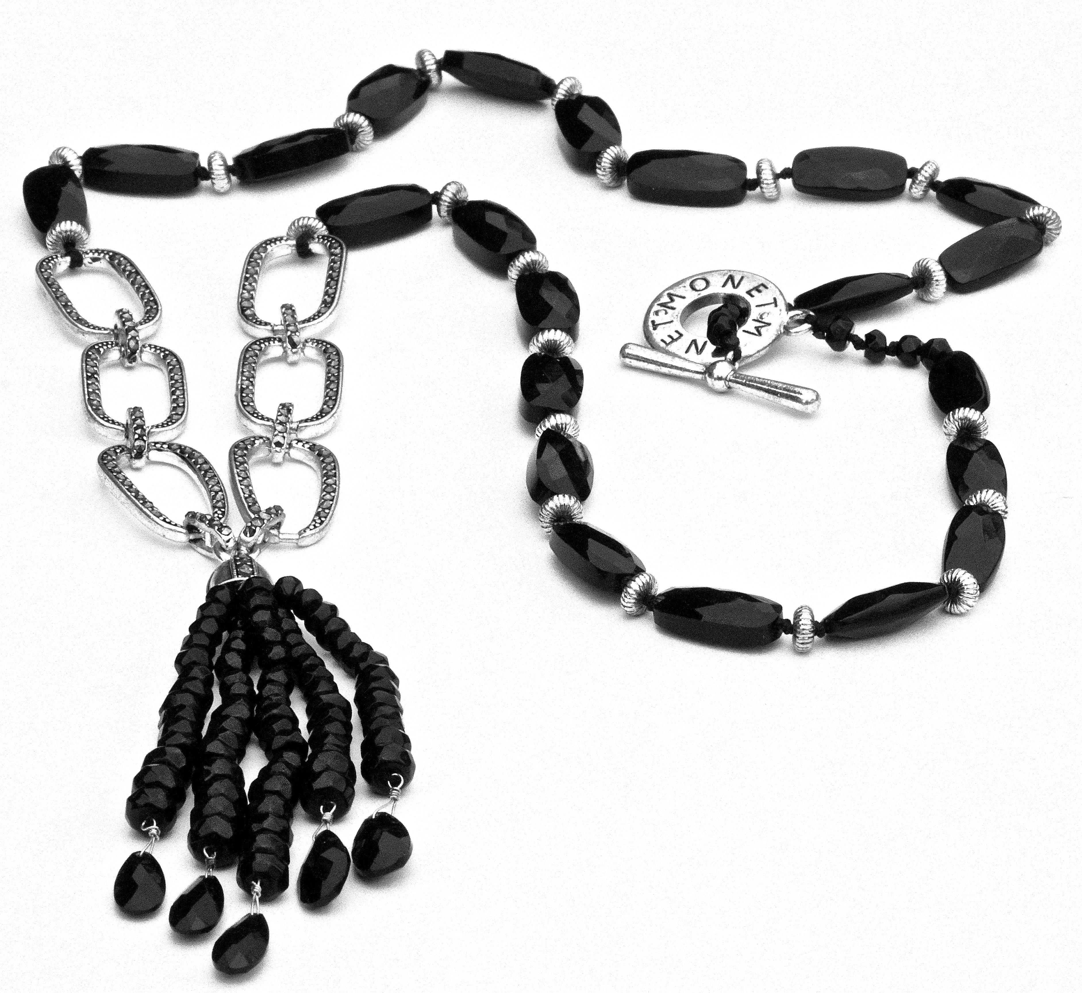 Unusual Monet silver tone faceted black glass and marcasite tassel necklace, with a toggle clasp.
The black glass beads are interspersed with silver tone ridged metal discs. Length 69.5cm, 27.36 inches, with a 9cm, 3.54 inches, five strand