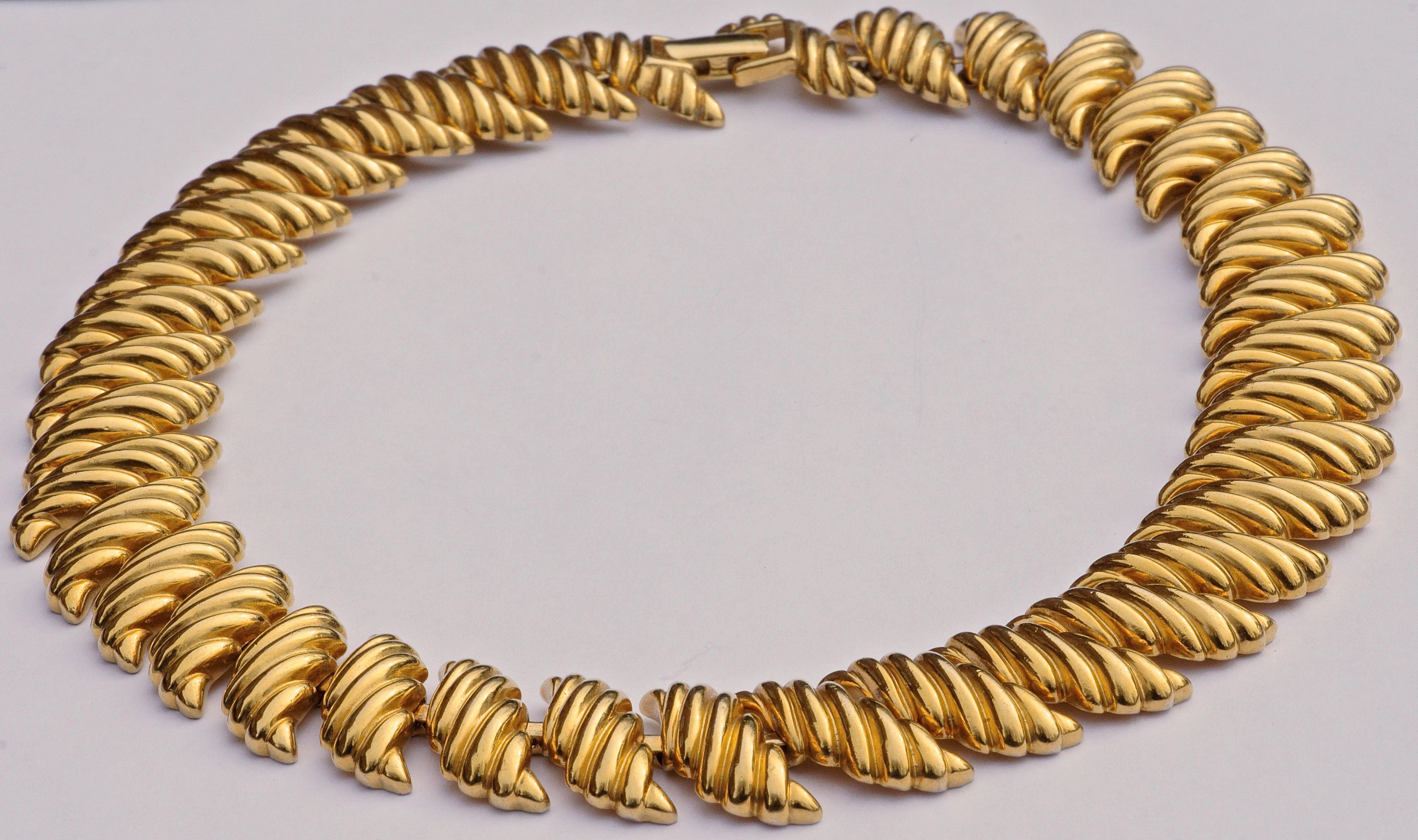 Napier stylish gold plated necklace featuring shiny ridged detail links, and a fold over clasp. Measuring length 45.7cm / 18 inches, by width 2.1cm / .83 inch.

This is a classic heavy vintage statement necklace in very good condition. Circa