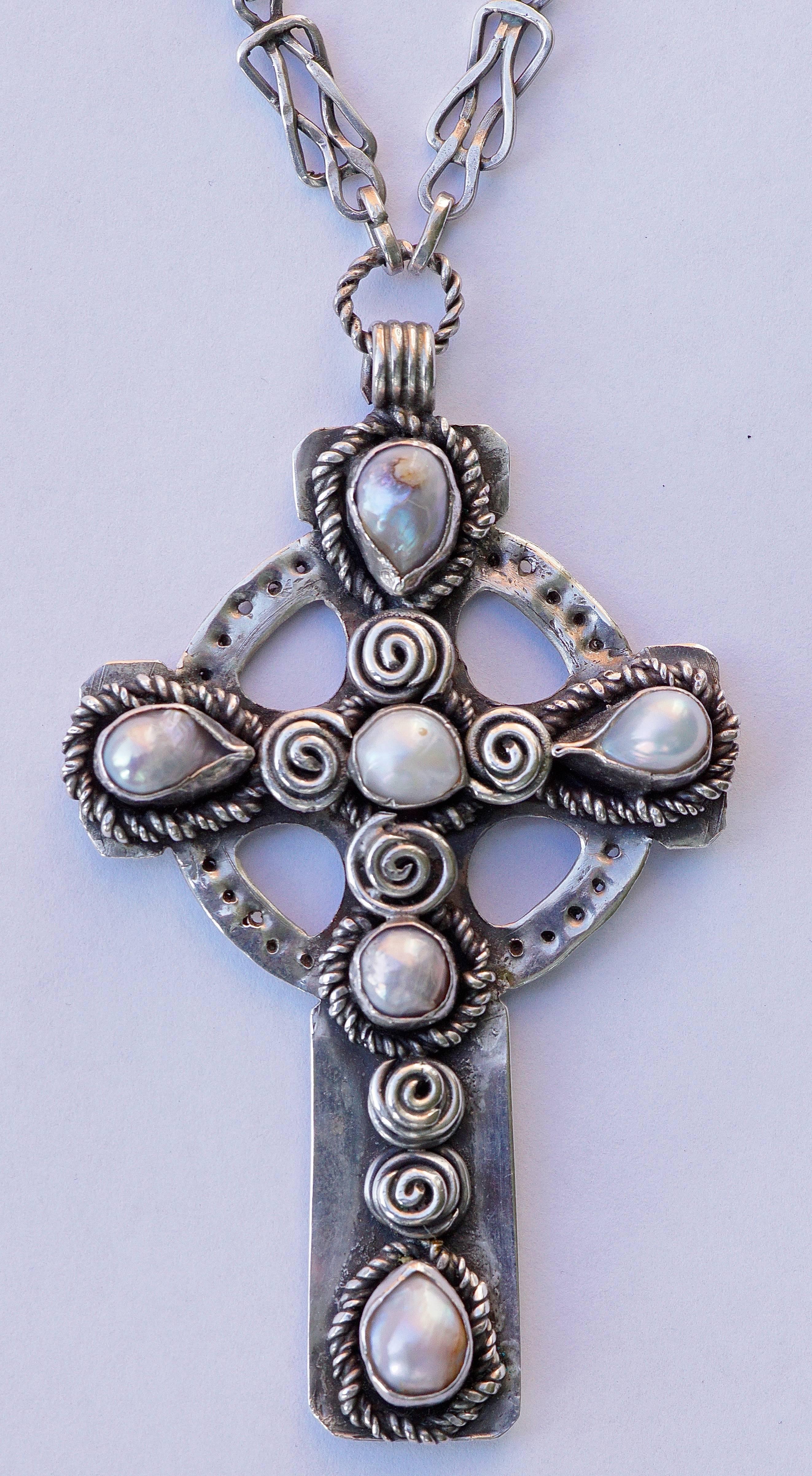 Fabulous silver and baroque pearl celtic design cross and chain, in very good condition. There are no hallmarks, but tests as silver, and weighs a substantial 49.5 grams.

The fancy link chain has a toggle clasp, and is length 64.5cm, 25.39 inches.