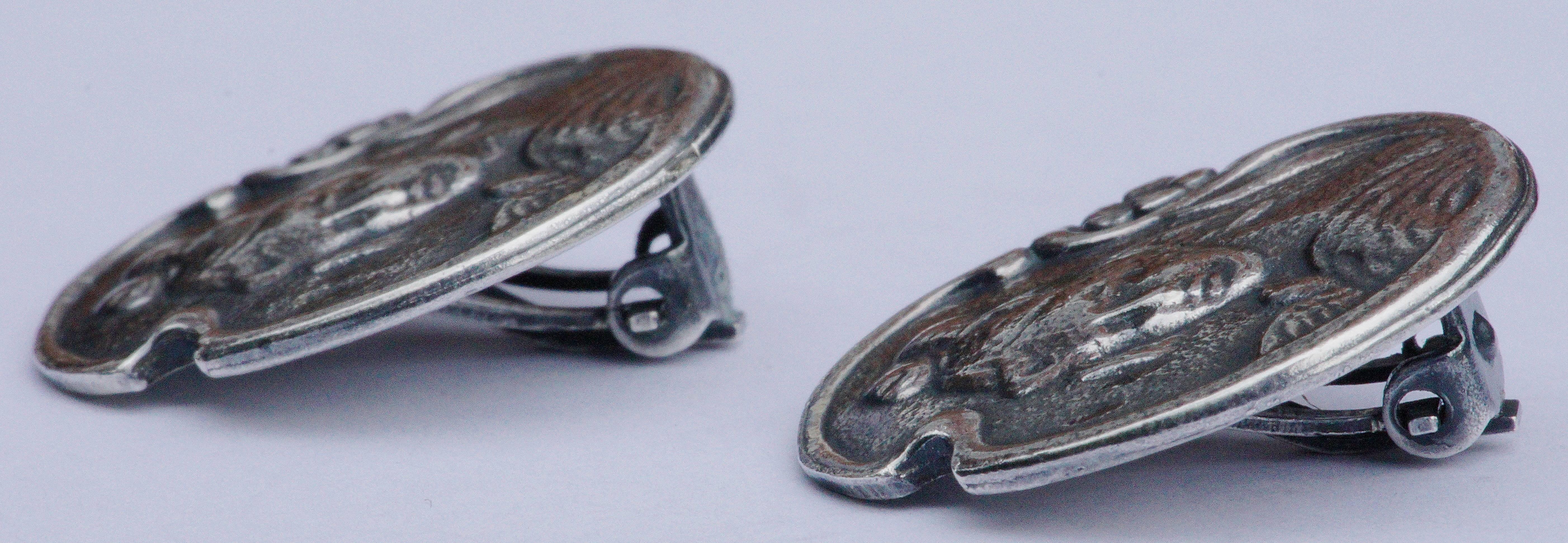 Original early twentieth century art nouveau silver clip earrings, measuring 2.3cm, .9 inch diameter. They are unmarked, but test as silver.

They have a wonderful lady and flower design. Art nouveau vintage earrings such as these are hard to find.
