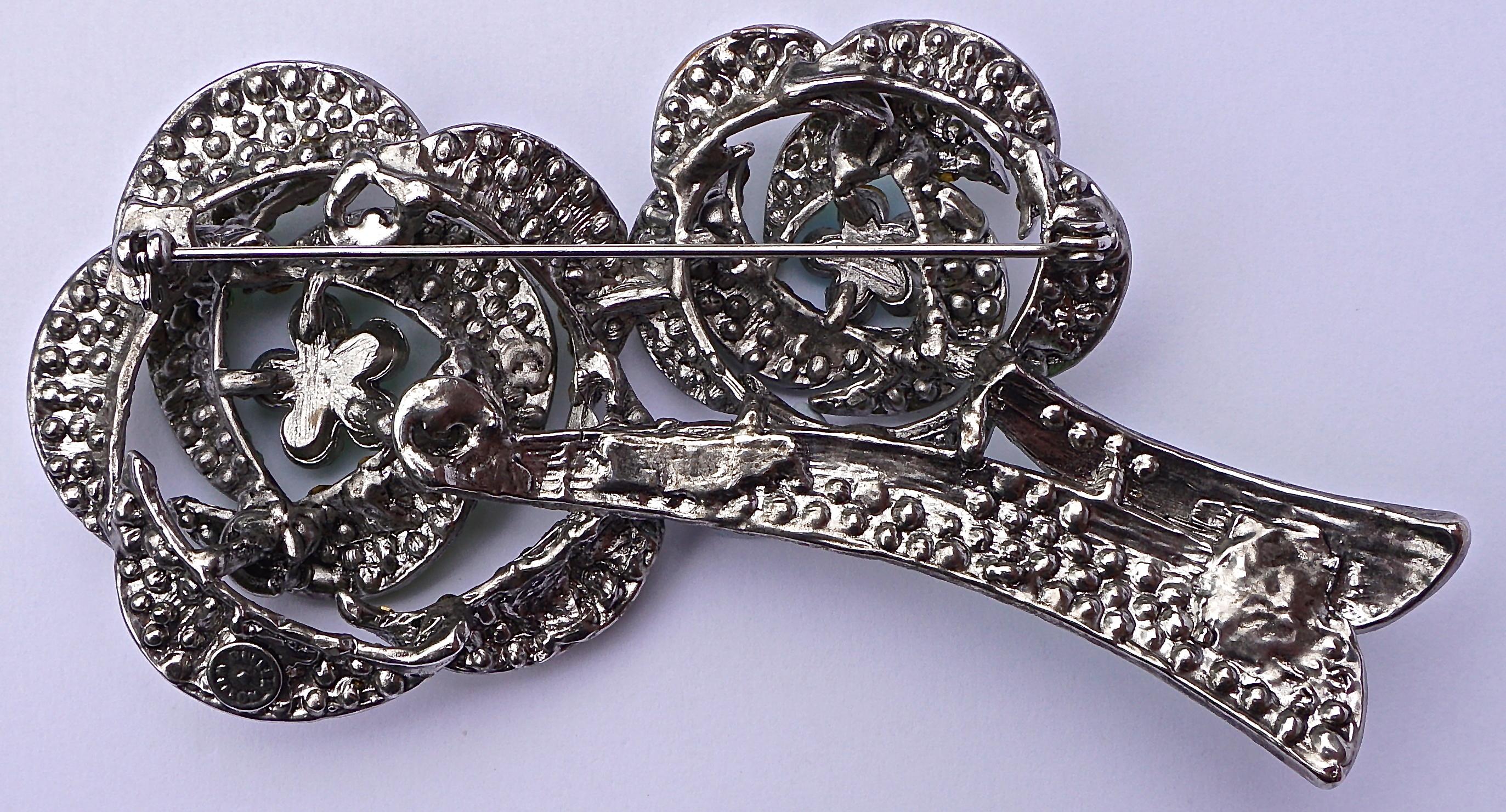 Butler & Wilson large vintage double flower brooch with two shades of sparkling green and aurora borealis rhinestones set in silver tone metal. Measuring length 10.4 cm / 4.09 inches, and the larger flower measures 4.8cm / 1.89 inches across.

This