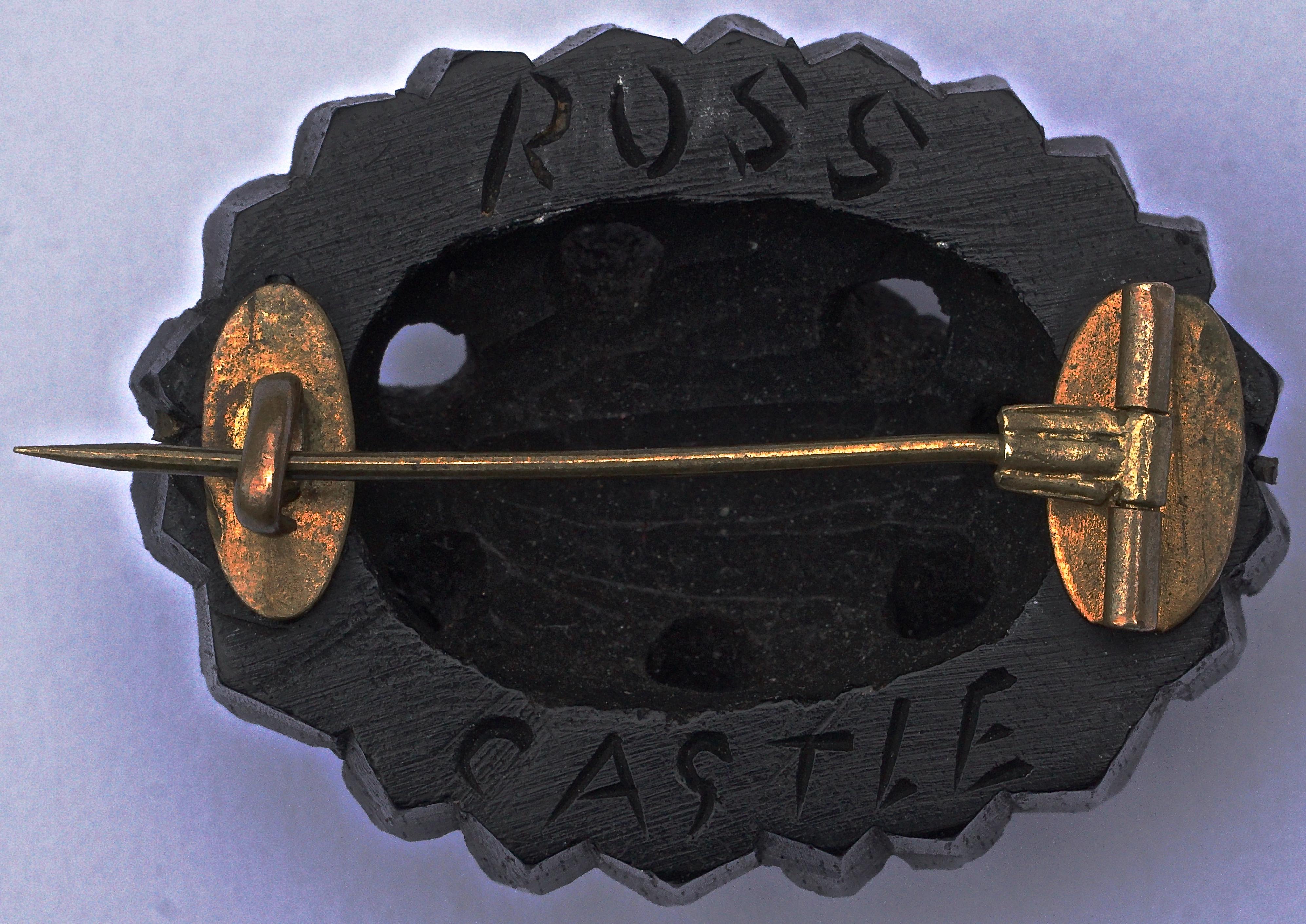 Victorian hand carved Irish bog oak brooch featuring Ross Castle in bas relief encircled by shamrocks. It has the old 'C' hook clasp and tube pin assembly in gold tone metal, which dates this lovely antique brooch to around 1890. The brooch measures