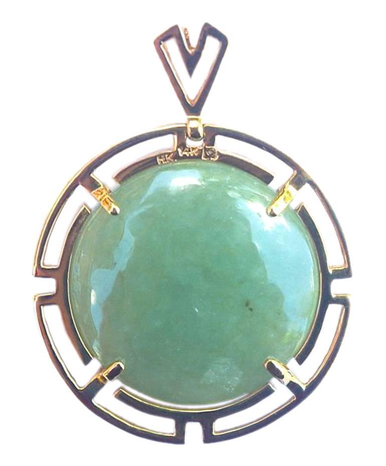Classic 14K gold pendant with a round, slightly dome shaped, jade stone, and a V shaped bale. Stamped H.K. 14K, and measuring 2.9cm (1.14 inches) diameter.

This beautiful polished jade pendant would look stunning with a modern or vintage outfit.

