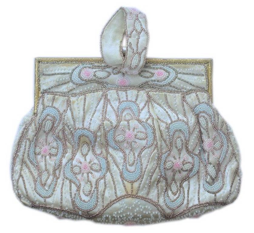 Art deco bag with blue and pink pastel beads, and white and bronze beads. Max. width approx. 18cm, 7.1 inches by approx. 14cm, 5 1/2 inches.
It has a beautiful golden filigree clasp set with blue rhinestones and milky white stones.
The reverse has a