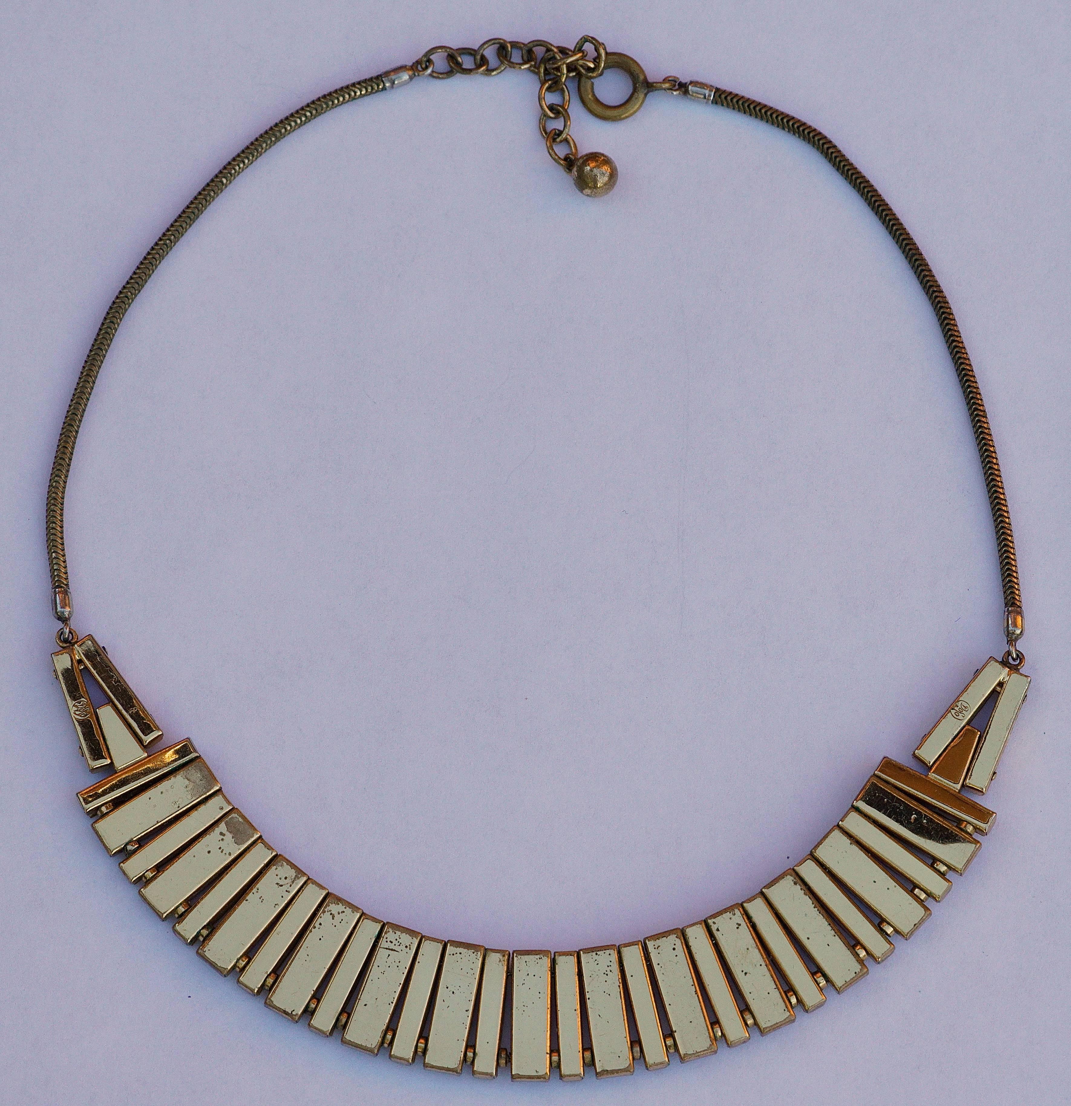 Fabulous gold plated original Art Deco necklace featuring channel set rhinestones and mother of pearl. The rhinestones and mother of pearl are separated by metal beads, to create the curve to go around the neck. The necklace has the German stamp