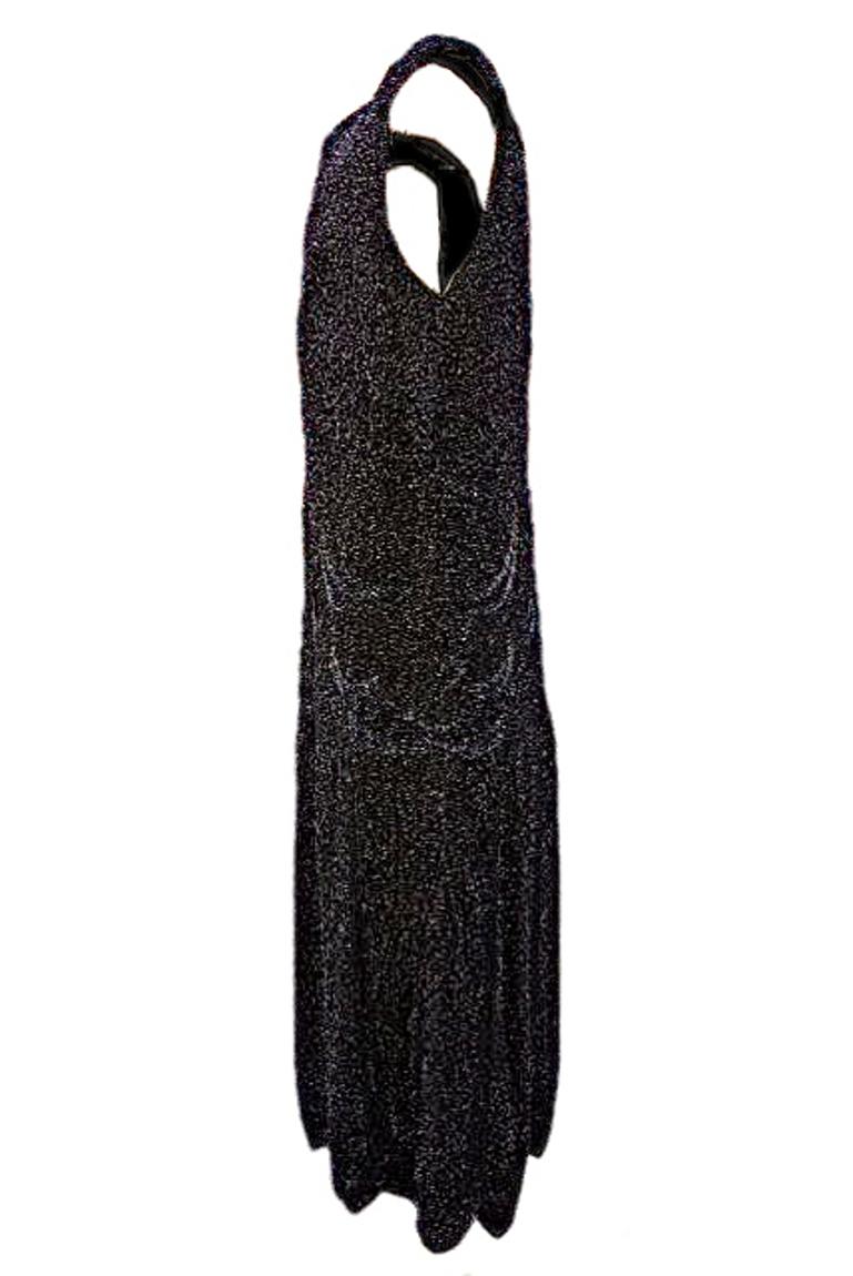 This heavy 1920s silk dress is embellished all over with black glass beads in a design typical of the Art Deco era.
The front and back are identical, and it is fully lined with black silk. It has a v-neck and lovely scalloped hem detail.
The dress