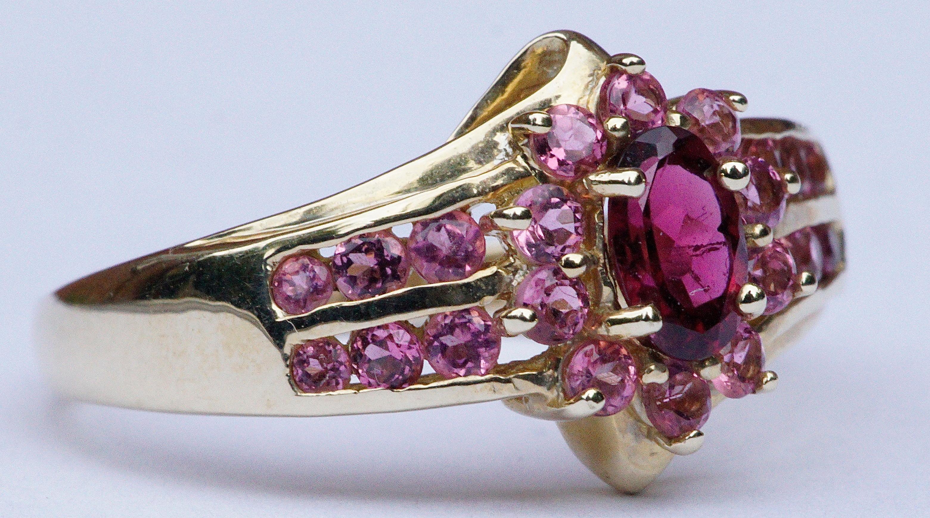 STS Jewels Inc. quality 14K gold ring, featuring a faceted deep pink natural tourmaline, and twenty two light pink gemstones. Twelve of the faceted light pink stones are channel set, six to each side, and ten are in a cluster around the tourmaline.