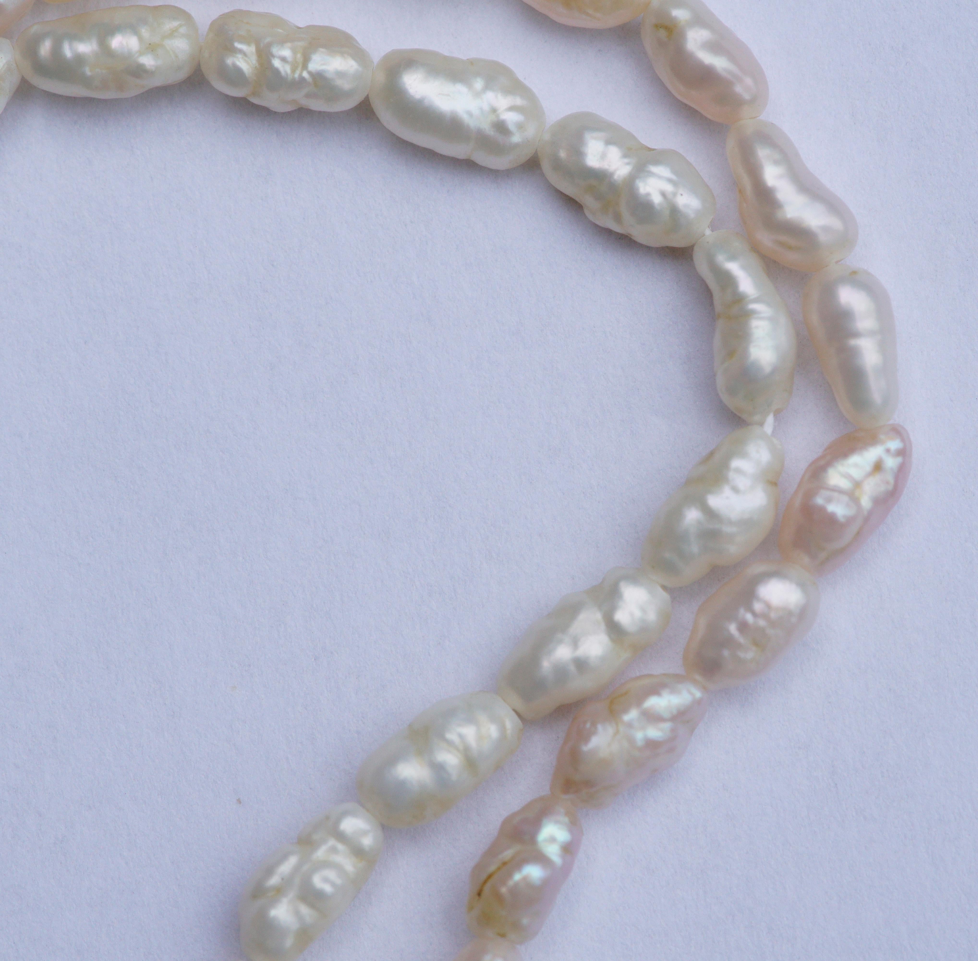 Two original strands of vintage baroque genuine rice pearls, circa 1970s. There is one white, and one very pale pink necklace. Both are length 81cms, 31.89 inches.

Each pearl is approximately length 6mm, .23 inch. They have a beautiful subtle