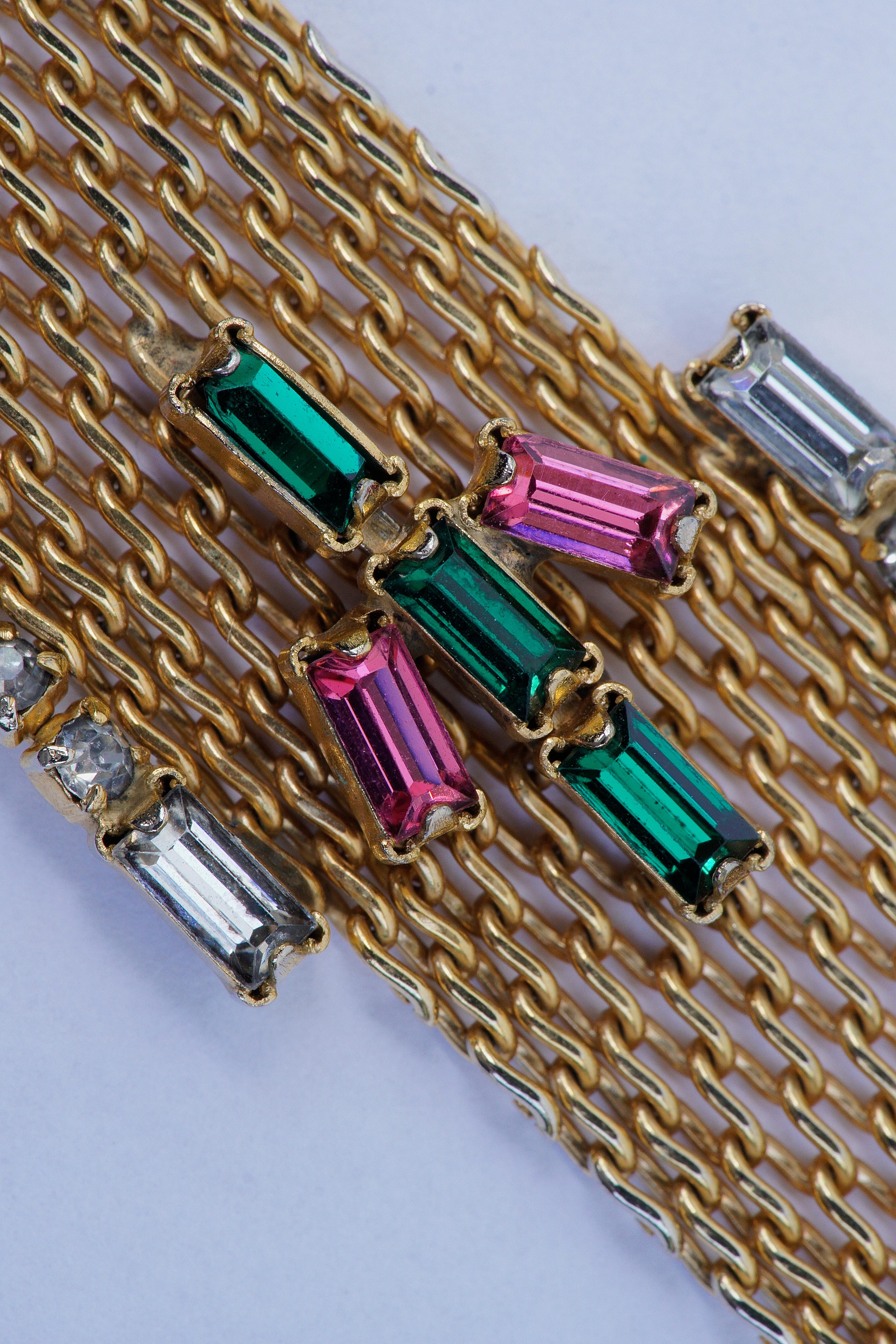 Hobé gold tone mesh bracelet embellished with clear, emerald green and pink rhinestones, circa 1950s. There are two places where the clear rhinestones have come detached from the mesh, but as this is not noticeable on wearing, we have left as is.