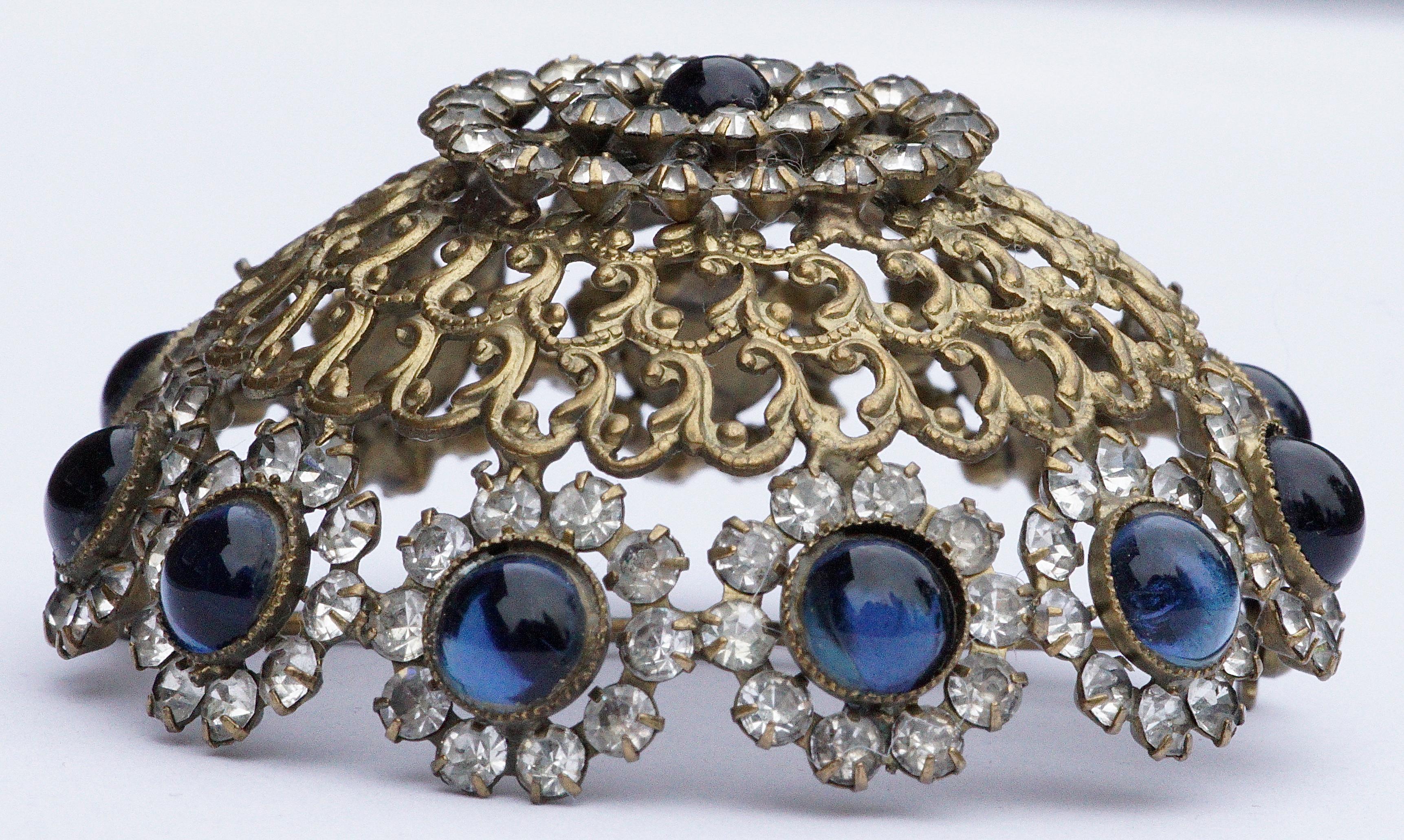Wonderful Alice Caviness dome brooch with golden metal swirl detail, and featuring blue glass cabochons and faceted clear rhinestones. The brooch measures diameter 5.5cm / 2.16 inches by height approximately 1.8cm / .71 inch.

This is a fabulous and