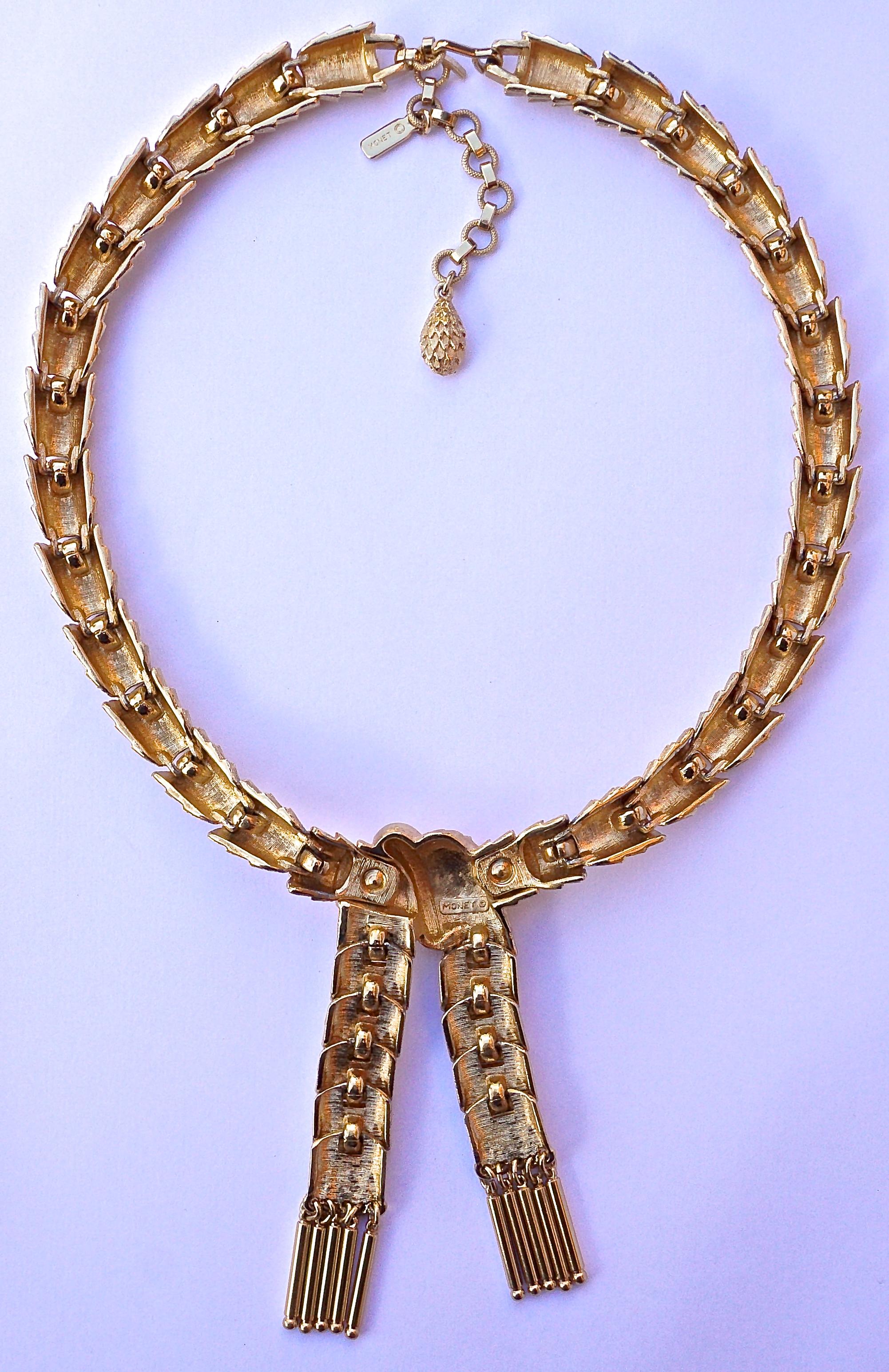 Fabulous Monet gold plated link textured collar necklace, featuring a ribbon design dropping from the necklace with shiny golden accents. It is in very good condition. The necklace measures length 44.5cm, 17.5 inches, including the extension, and