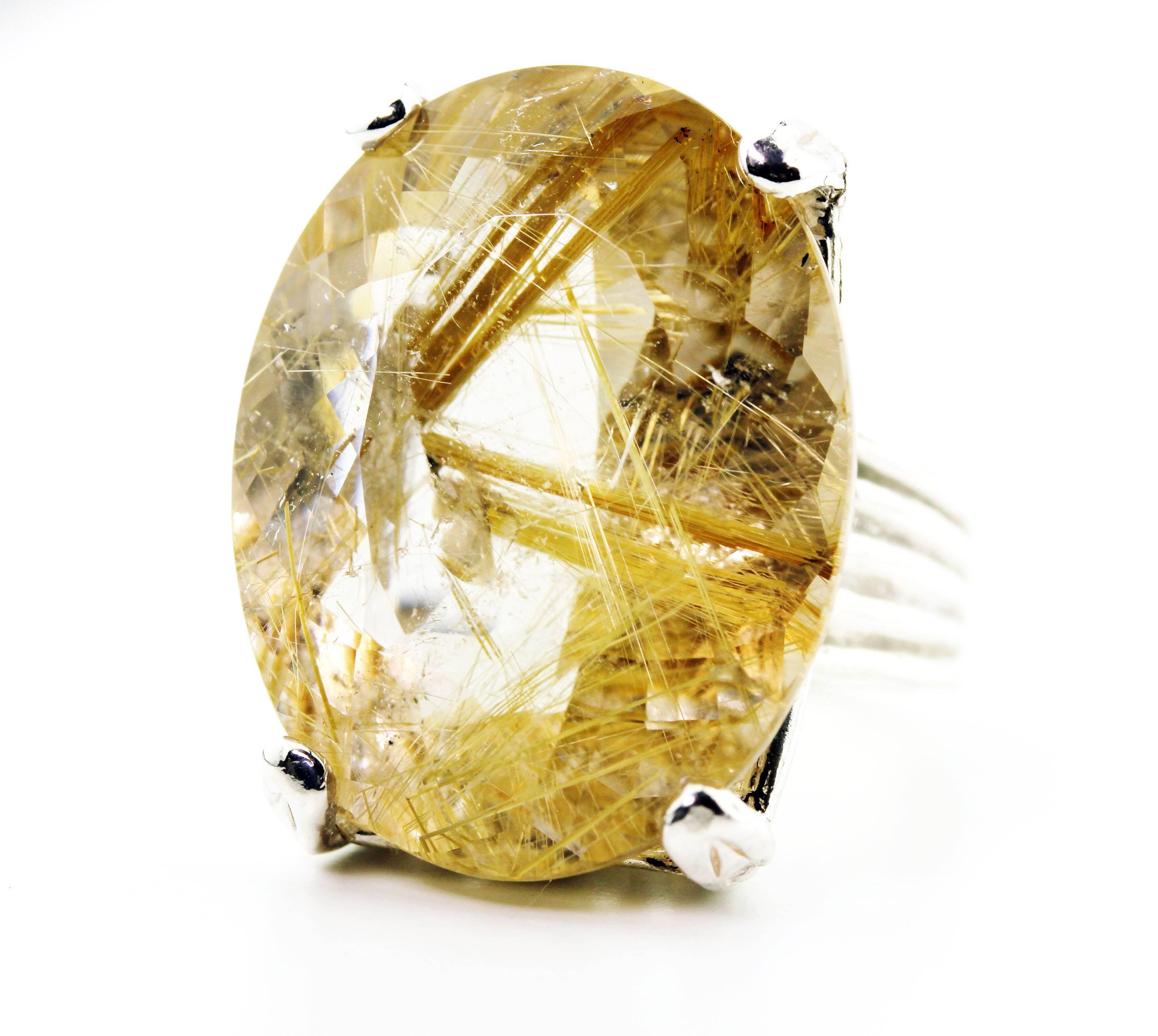 Golden translucent 77.20 carat sparkling Rutilated Quartz - gold color rutilation -  set in a Sterling Silver ring size 8.5 (sizable).  The gemstone measures 28.3 mm x 22 mm.    More from this seller by putting gemjunky into 1stdibs search bar.