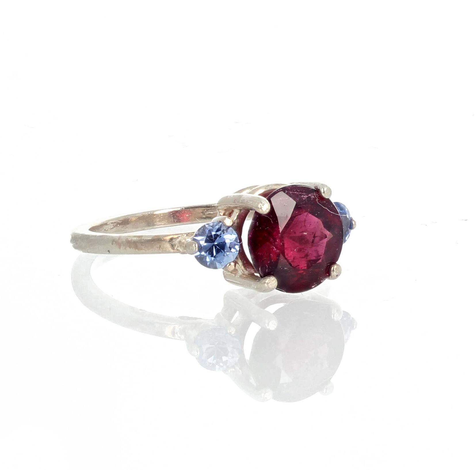 Bright glowing unique 1.4 carat deep red Rubellite Tourmaline enhanced with natural brilliant blue Sri Lankan Sapphire side stones set in a sterling silver ring size 7 (sizable).  